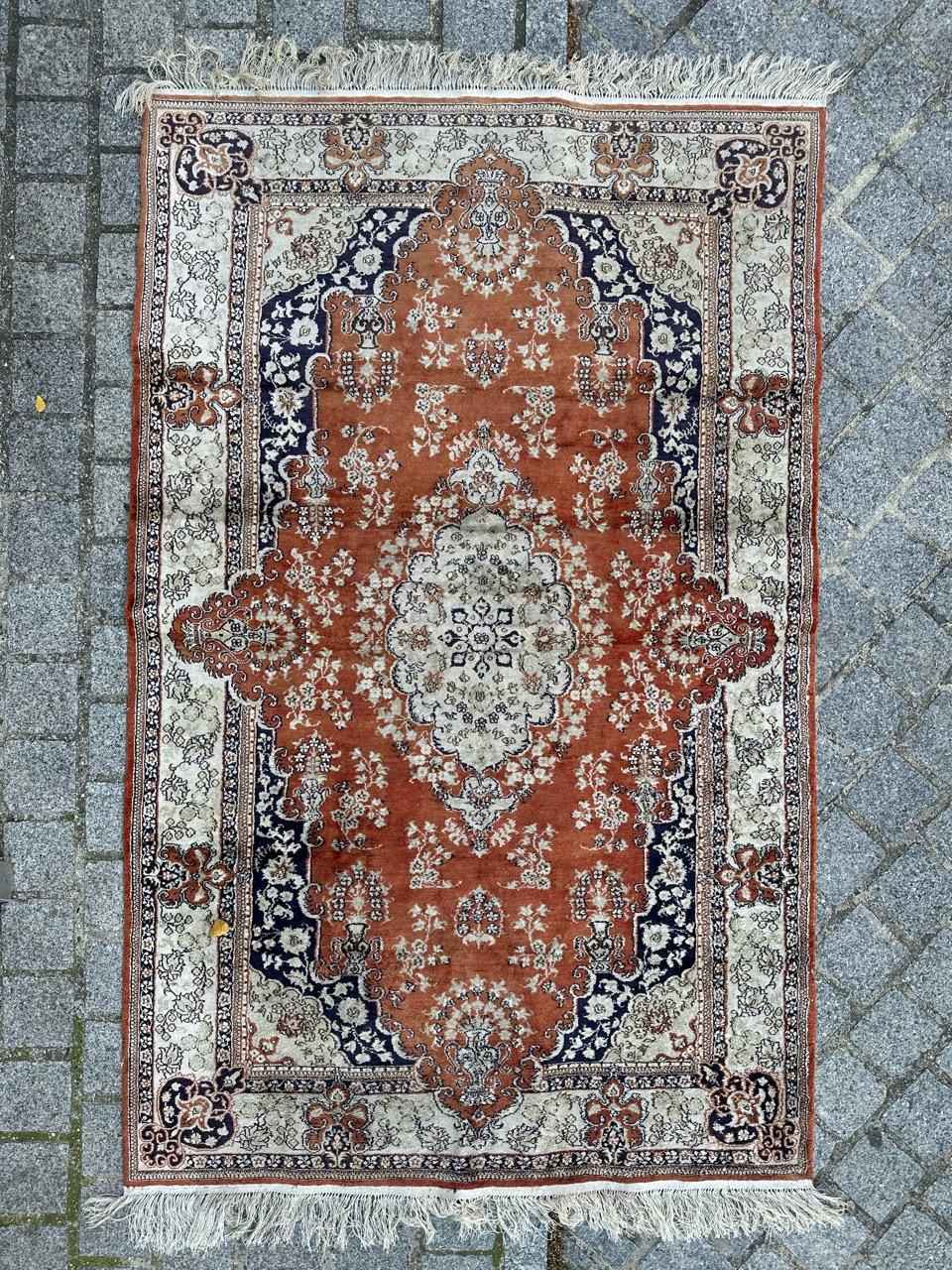 Wunderschöner Vintage-Seidenteppich im Stil der persischen Qom-Teppiche, in China sorgfältig handgeknüpft. Dieses exquisite Stück zeichnet sich durch komplizierte, handgewebte Blumenmuster in schönen Farben aus. Das orangefarbene Feld ist mit einem