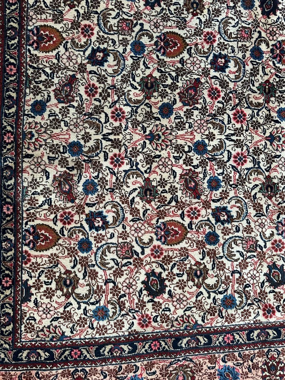 Discover the timeless elegance of our large mid-century Mashhad rug! Adorned with a beautiful floral design in vibrant colors such as orange, pink, red, blue, green, and brown, this hand-knotted masterpiece features wool velvet on a cotton