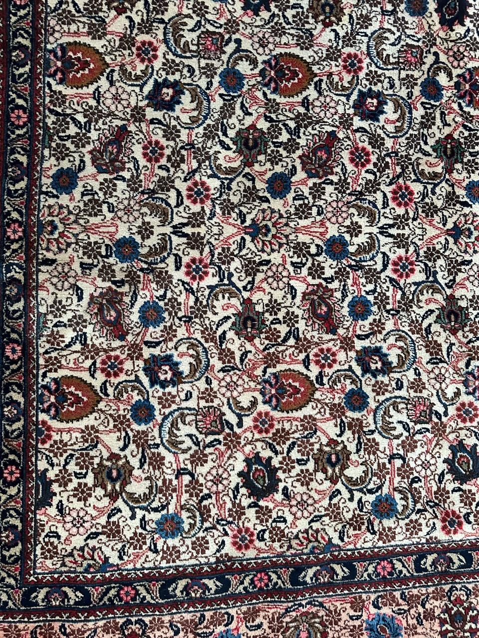 Scopri l'eleganza senza tempo del nostro grande tappeto Mashhad di metà secolo! Adornato da un bellissimo disegno floreale in colori vivaci come l'arancione, il rosa, il rosso, il blu, il verde e il marrone, questo capolavoro annodato a mano