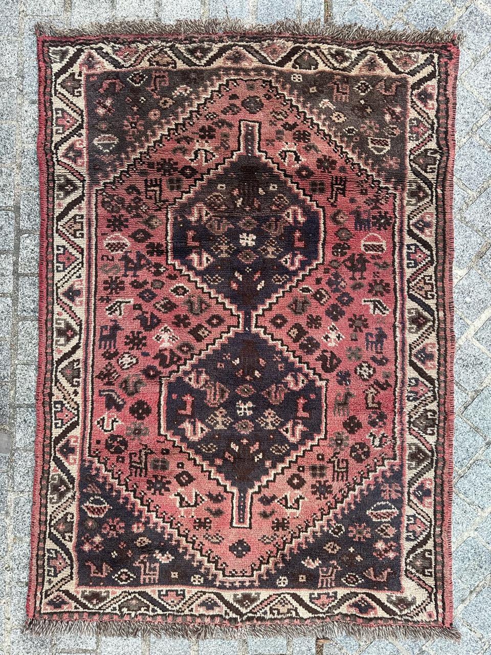 Bellissimo tappeto Shiraz vintage della seconda metà del XX secolo. Annodato a mano con intricati disegni geometrici e stilizzati in colori vivaci. Il campo rosa è ornato da piccoli motivi stilizzati grigi, verdi, bianchi e marroni. Due medaglioni