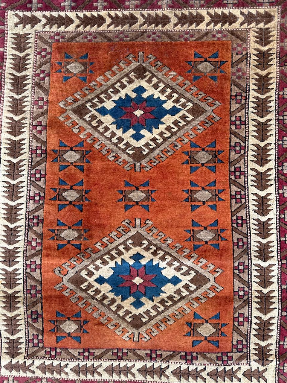 Nice vintage Turkish rug with beautiful design of Caucasian rugs with geometrical design and nice colours with an orange field, blue, green, white and pink in design, entirely hand knotted with wool on wool foundation 
small trace of wear