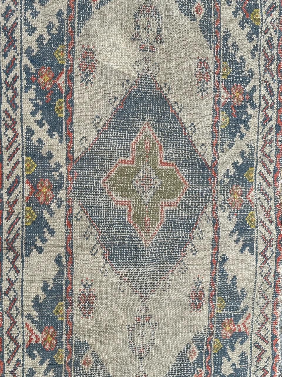 Joli petit tapis oushak turc ancien, avec un design décoratif et de belles couleurs claires avec du blanc sur le fond, du bleu, du vert, du jaune, du rose et du rouge, entièrement noué à la main avec de la laine sur une base en coton.