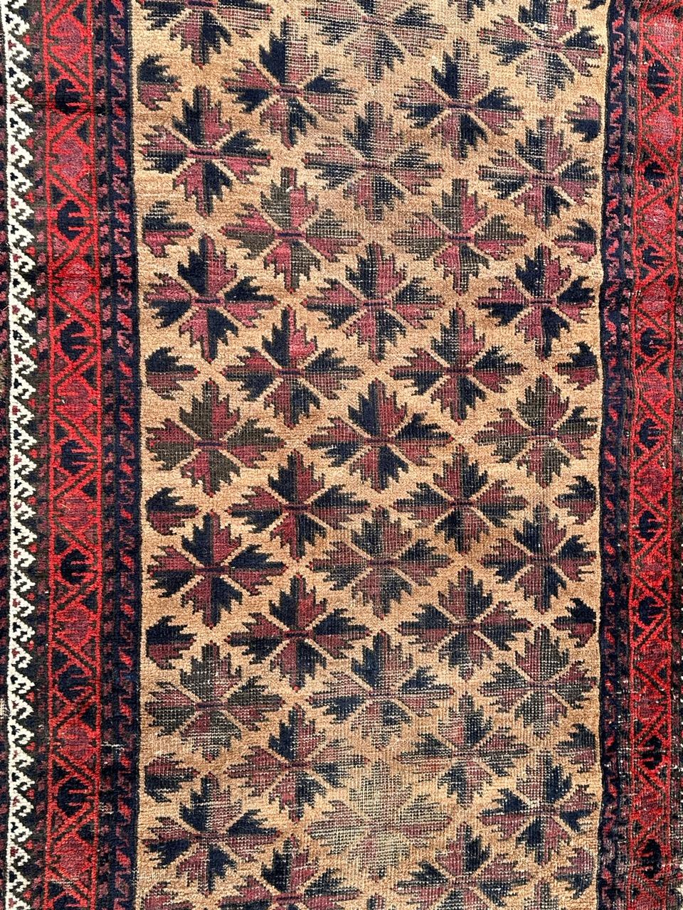 Pretty early 20th century Turkmen Baluch rug with nice tribal design with stylized flowers and nice natural colours with a yellow field, purple, navy blue, and red and white. Wears and little loses, due to the age and use, entirely hand knotted with