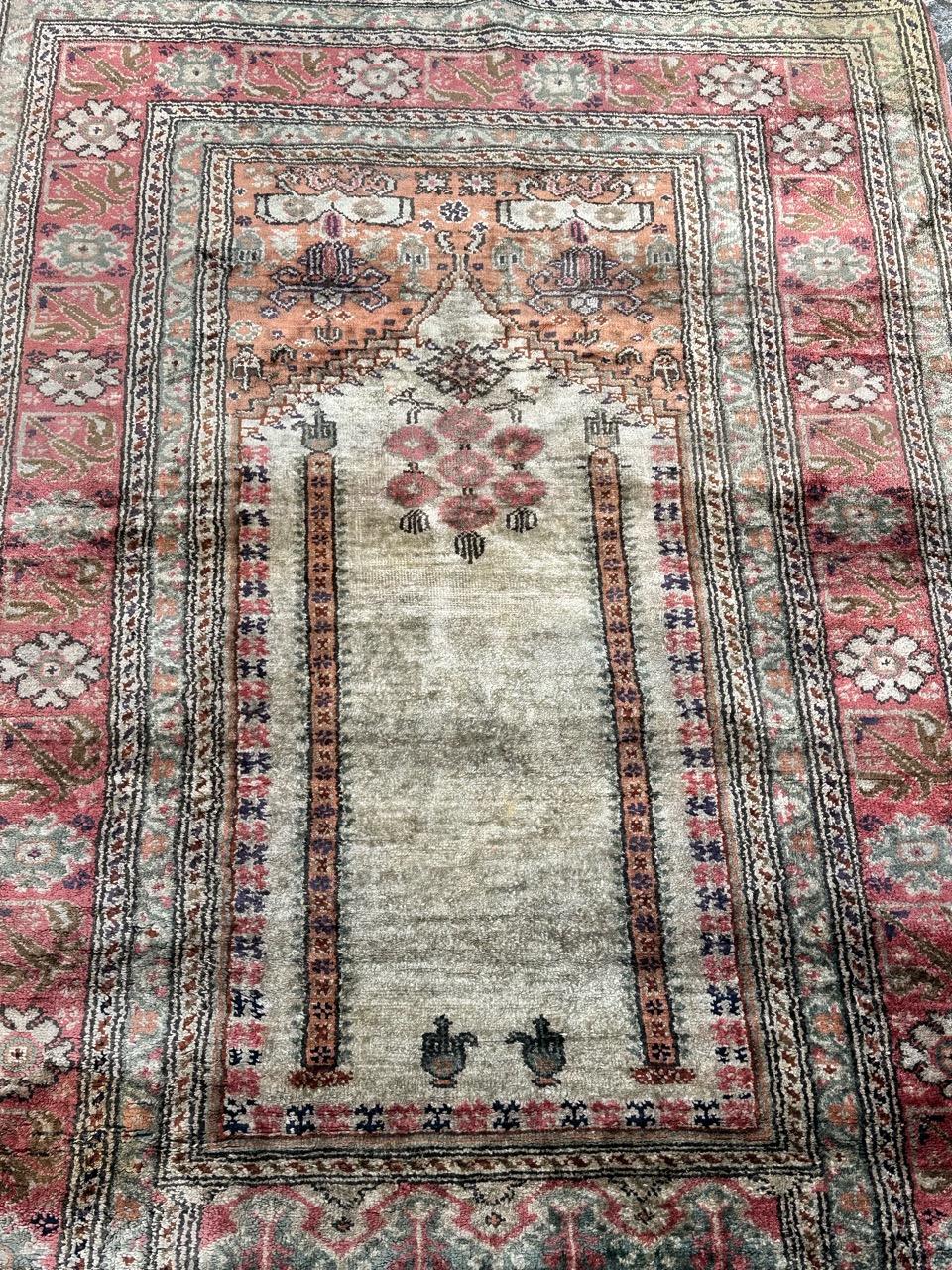 Pretty mid century Turkish Cesareh rug with beautiful mihrab design showing an entrance with columns and the stylized decorations and flowers, surrounding it. With nice light colours with a light green, orange, pink and grey. Entirely hand knotted