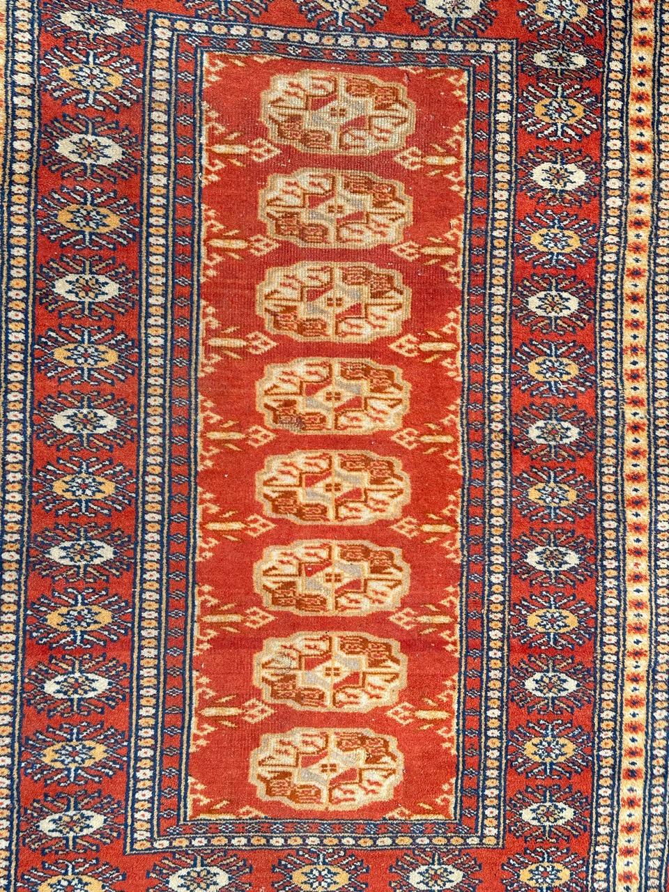 Joli petit tapis pakistanais vintage avec un joli design géométrique dans le style des tapis turkmènes de Bokhara, et de belles couleurs avec un champ orange, rouge, gris, blanc et noir, entièrement et finement noué à la main avec de la laine sur