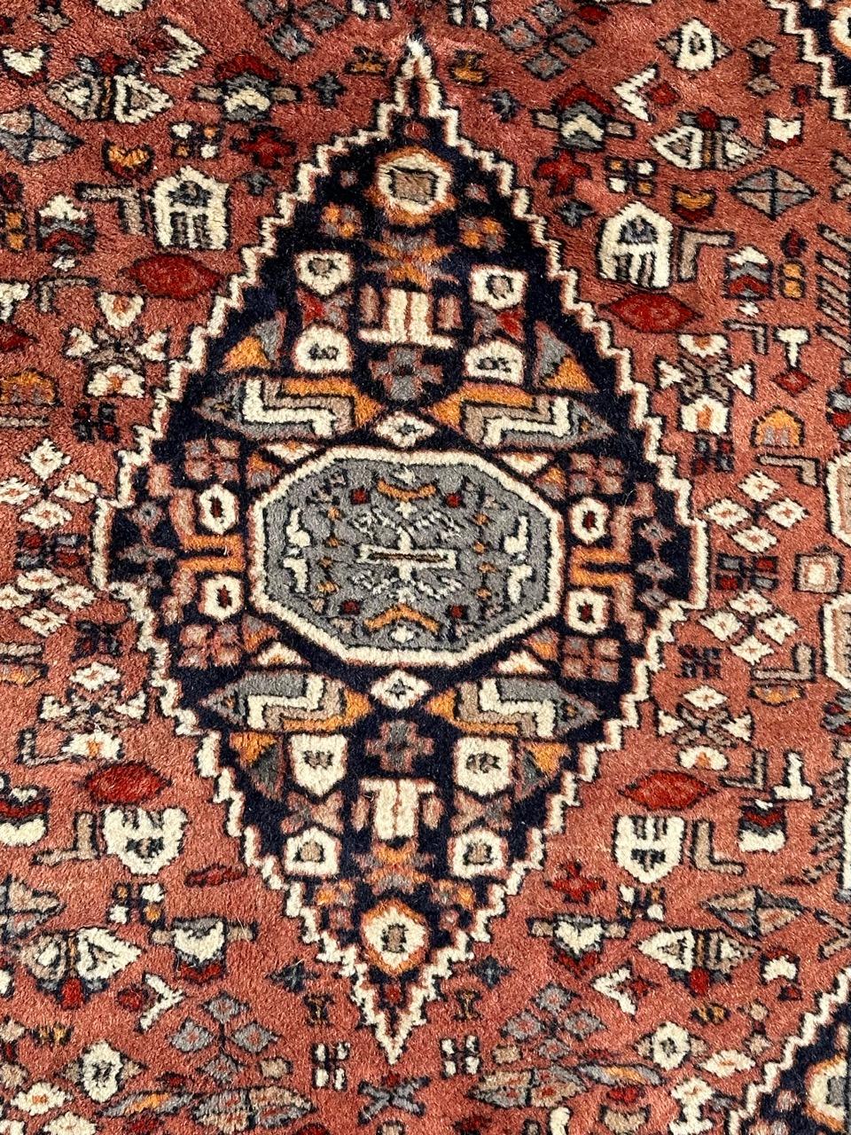 Pretty small vintage Pakistani rug with nice geometrical design in style of Tabriz rugs, and beautiful colours with orange pink field, grey, red, beige, orange, sky blue, dark blue, white and black, entirely and finely hand knotted with wool on
