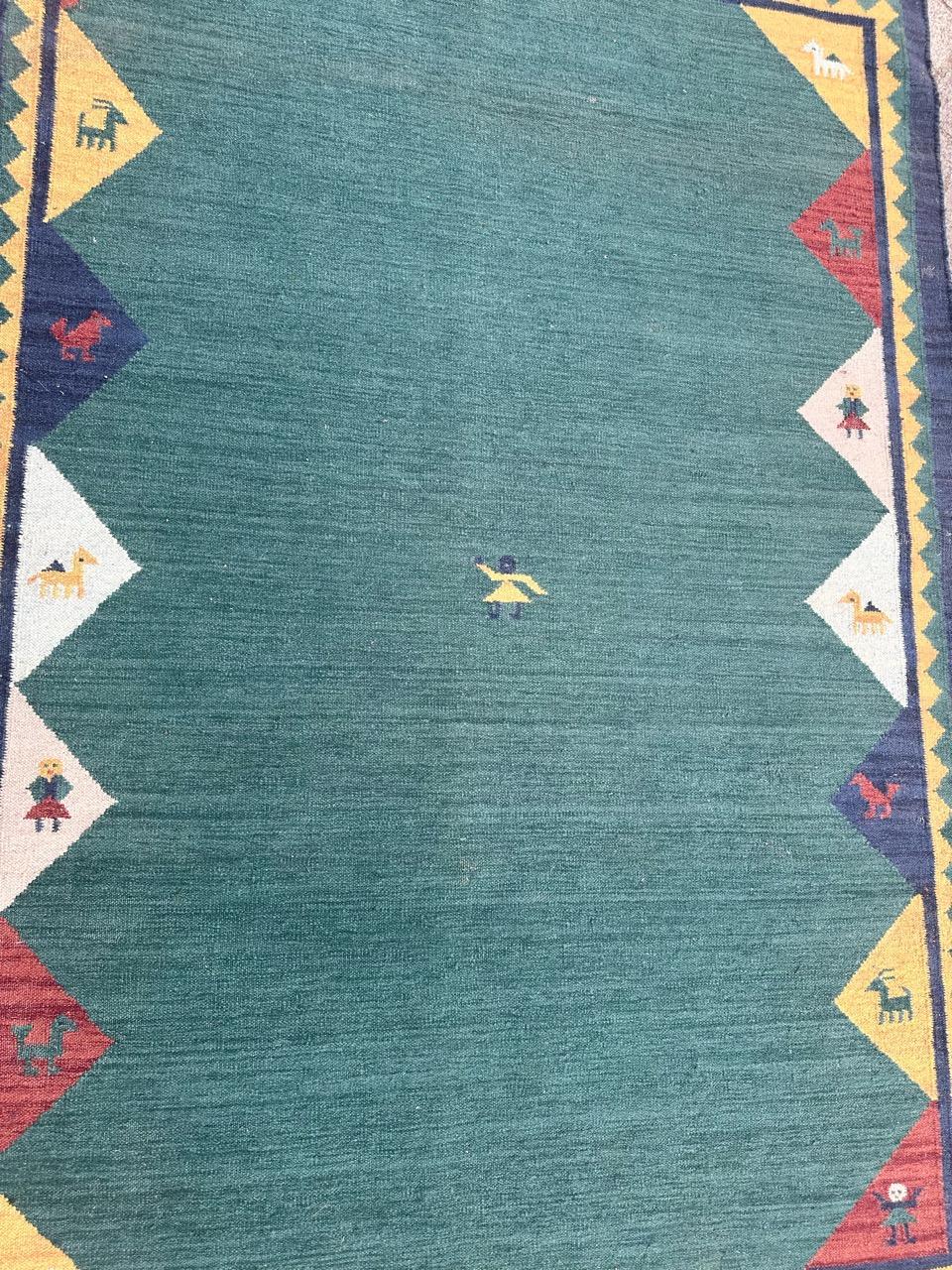 Magnifique Rug & Kilim indien vintage avec le design des tapis gabbeh et de belles couleurs avec un champ vert, bleu, jaune, rouge, rose et blanc, entièrement tissé à la main avec de la laine sur une base de coton. 

Magnifique tapis pakistanais