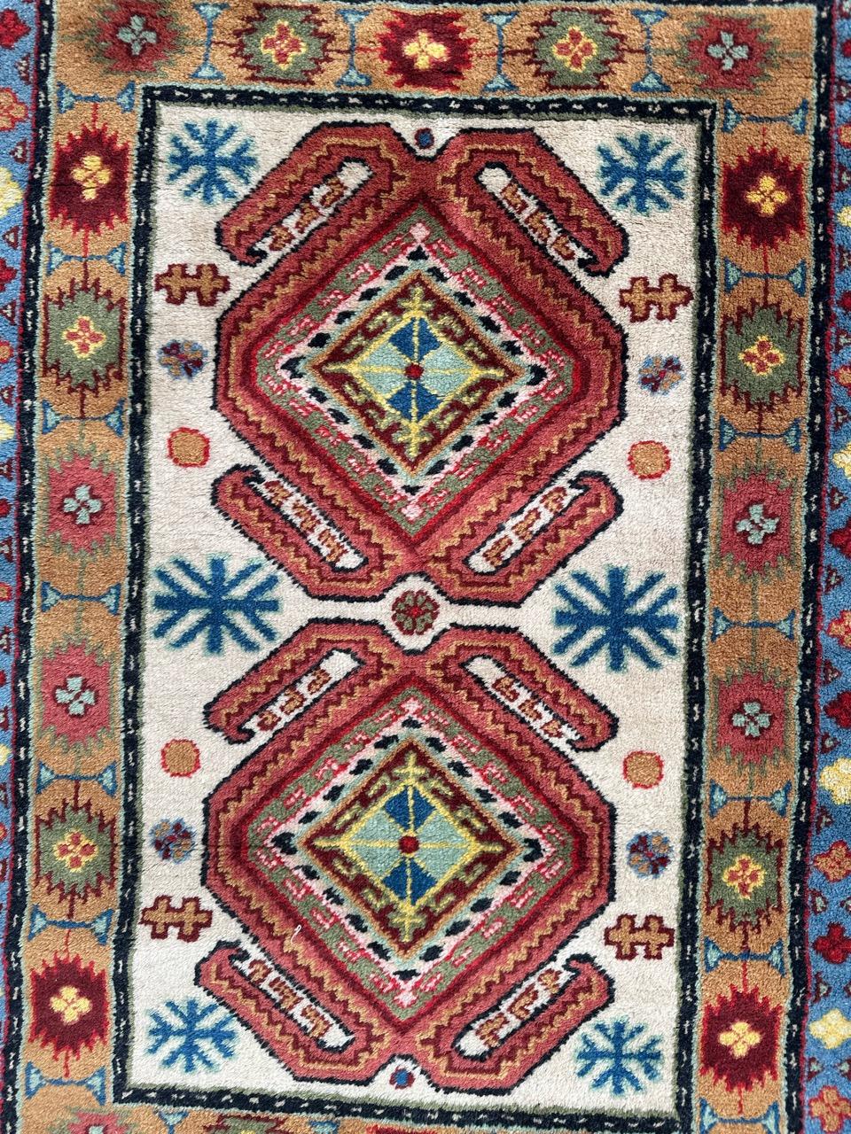 Schöner chinesischer Sinkiang-Teppich aus der Mitte des Jahrhunderts mit schönem Design im Stil der antiken kaukasischen Teppiche und schönen Farben mit einem schönen weißen Feld und lila, rosa, blau, grün auf Design mit einem blauen und