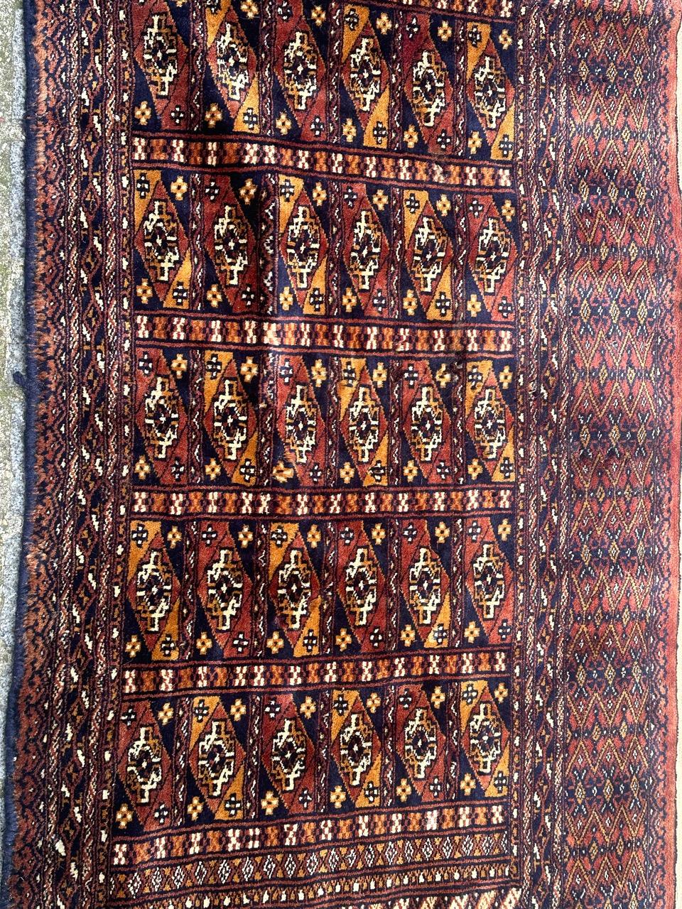 Magnifique tapis vintage turkmène de style chuval avec un beau design de Bokhara et de belles couleurs avec du rouge orange, jaune, bleu, violet et blanc, entièrement et finement noué à la main avec de la laine sur une base de coton.