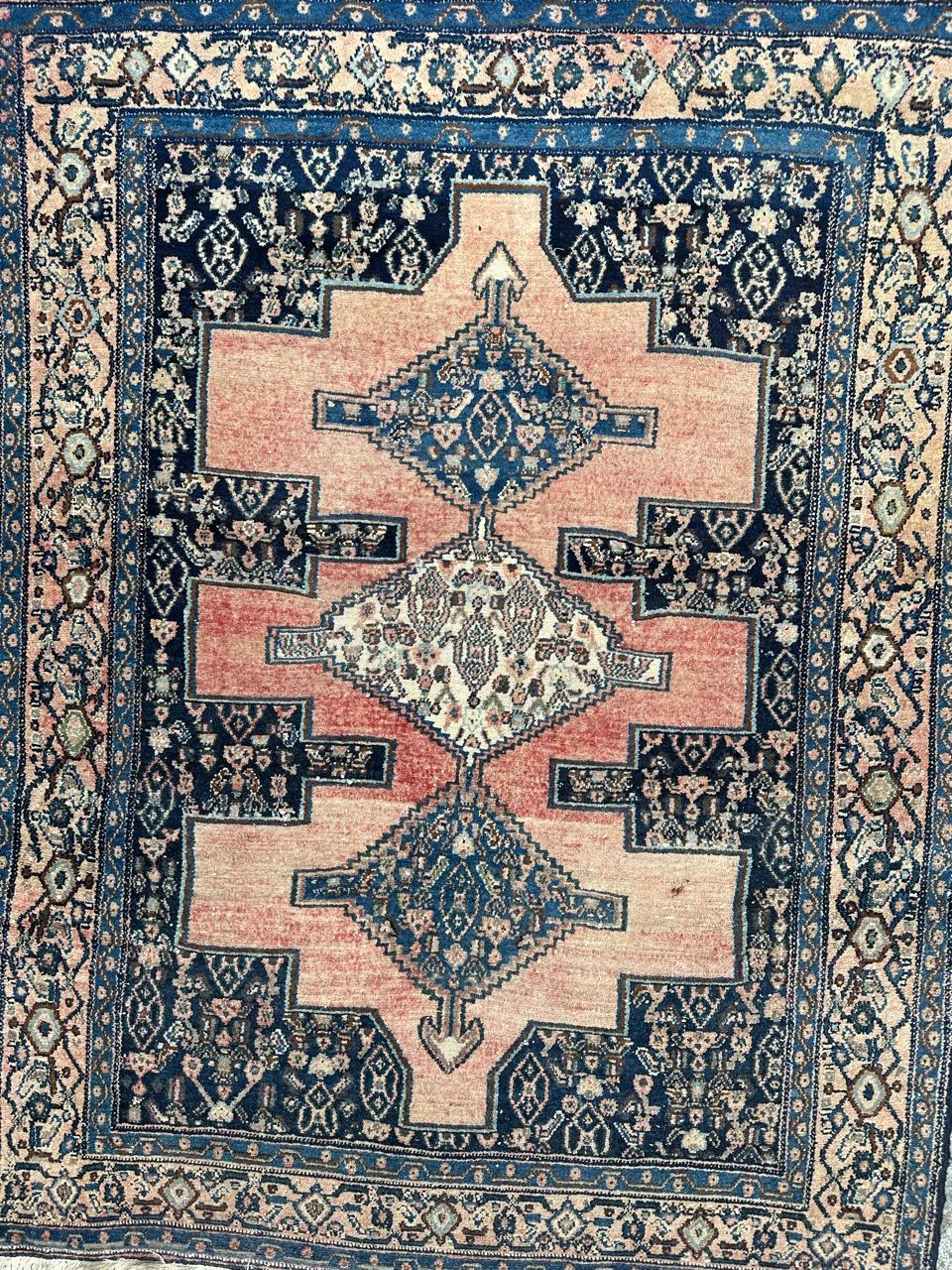 Joli tapis Senneh du milieu du siècle avec de beaux motifs géométriques et tribaux et de belles couleurs avec du rose, de l'orange, du bleu marine, du bleu et du marron, entièrement noué à la main avec de la laine sur une base de coton.
