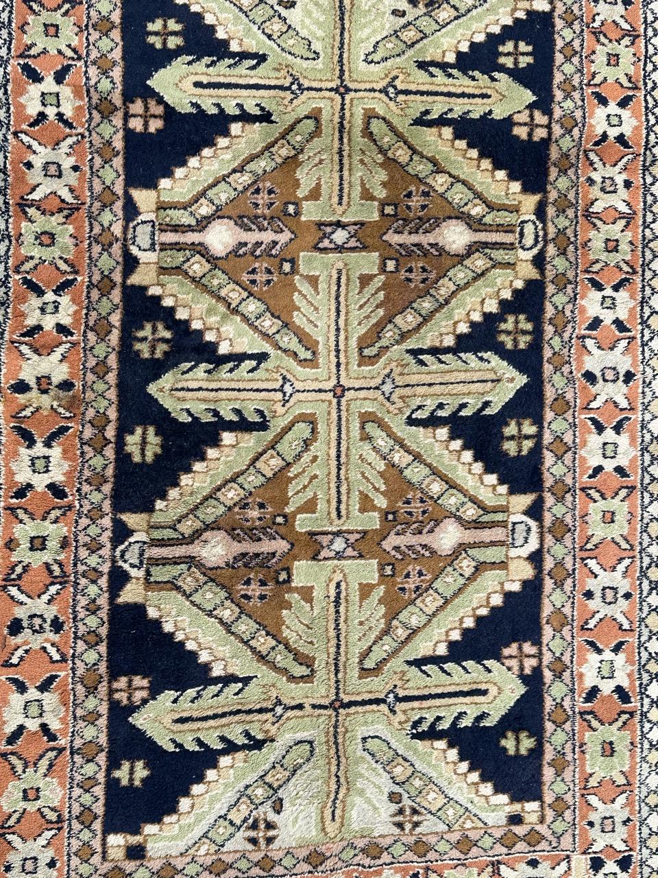 Pretty mid century Turkish Anatolian rug with beautiful geometrical Caucasian design and nice colours with a dark blue field and green, brown, pink on design, also an orange field border surrounding the field. Entirely hand knotted with wool on wool