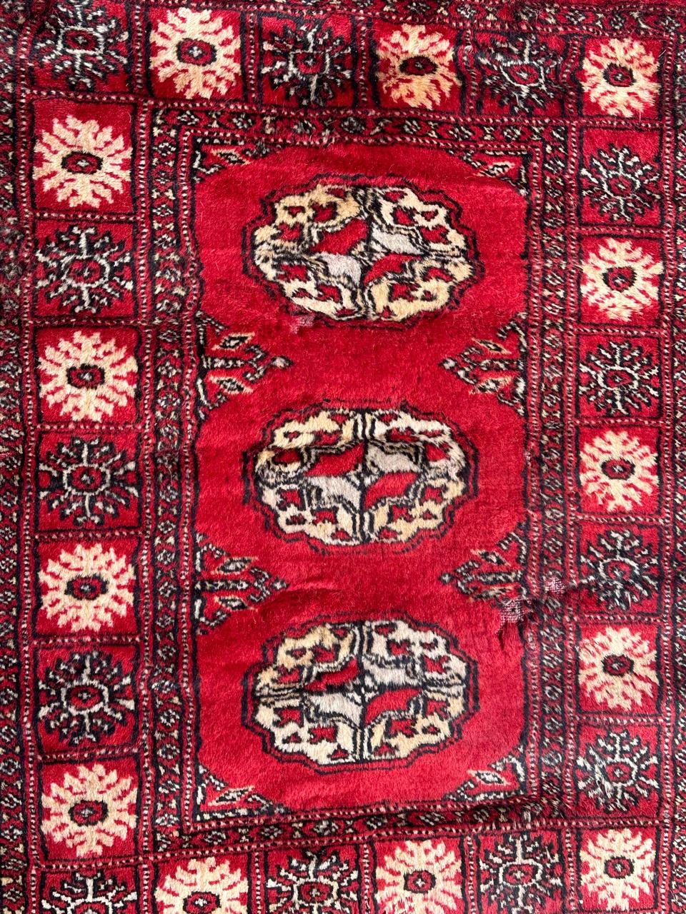 Vintage Bokhara design Pakistani rug with a red field colour and white, gray and black, entirely hand knotted with wool on cotton foundation 
Some wears 