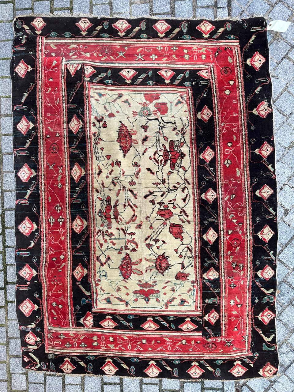 Exquisite antique Indian Agra rug from the mid-19th century. This masterpiece is entirely hand-knotted with wool on a cotton base, featuring a decorative design on a white background adorned with stylized red floral patterns. The red and black