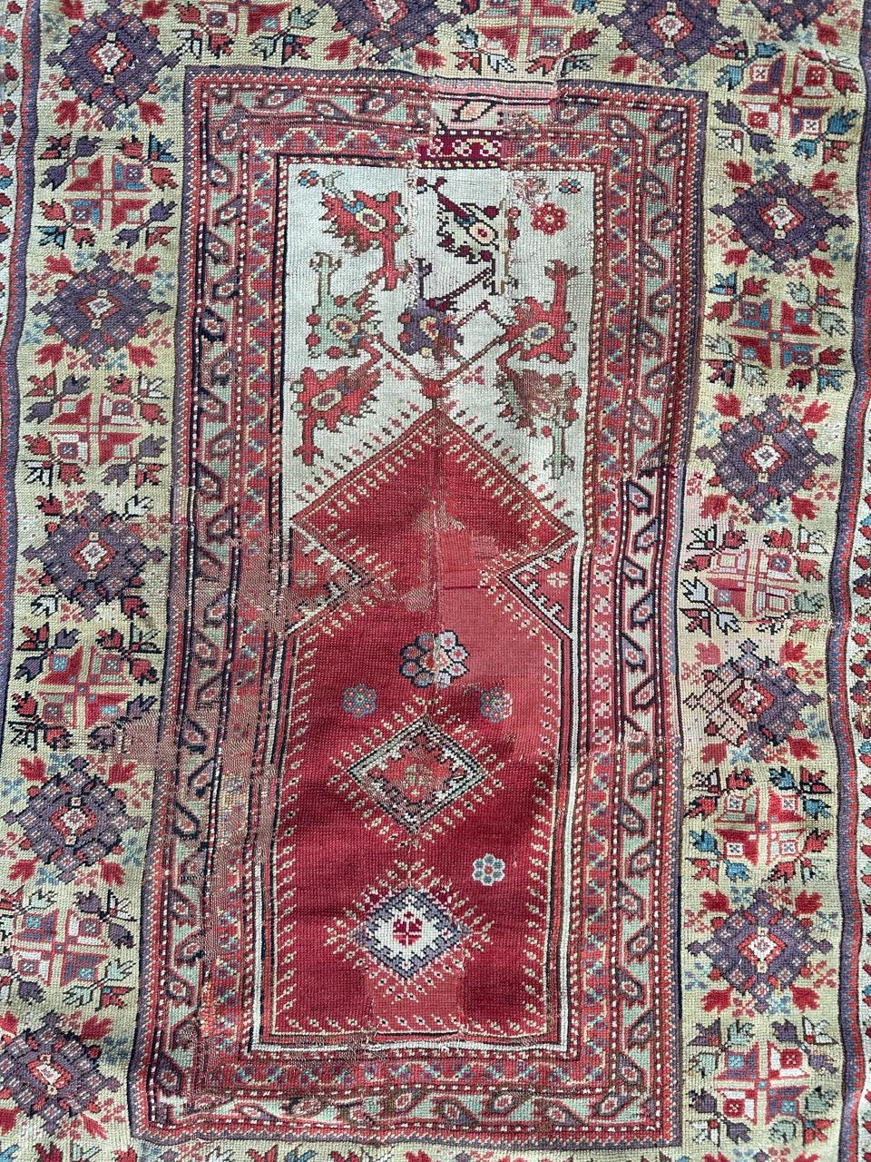 Nice antique collectible Turkish rug, probably from the first half of 19th century, with beautiful  mihrab design and nice natural colours with a red field, white, light green, purple and black. There’s some old repairs. Entirely and finely hand