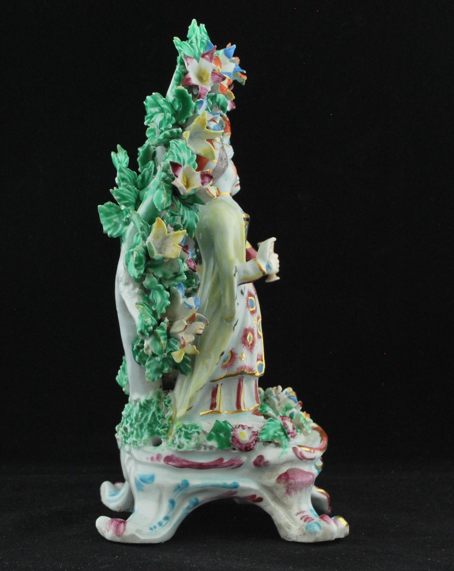 A girl and boy in Turkish costumes, standing amidst flowers on a Rococo base enriched in puce and gilt and in front of a flowering bocage of enameled leaves and flowers. A curious under-glaze blue crescent mark to the base.

Prov: Taylor