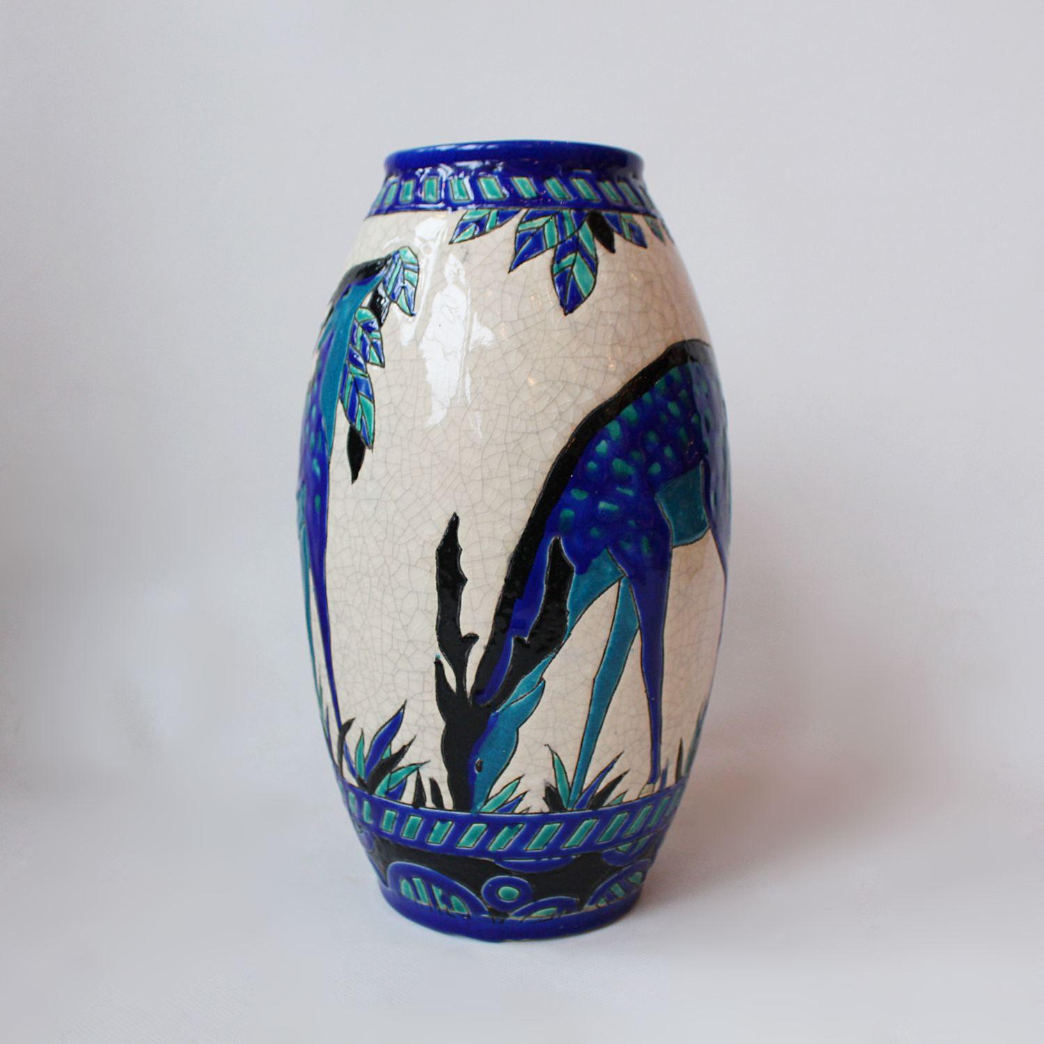 'Biches Bleues' An Art Deco, crackle glazed ceramic vase designed by Charles Catteau (1880-1966) for Boch Frères. A tapered vase painted with grazing deer in shades of blue. Numbered to underside.




  