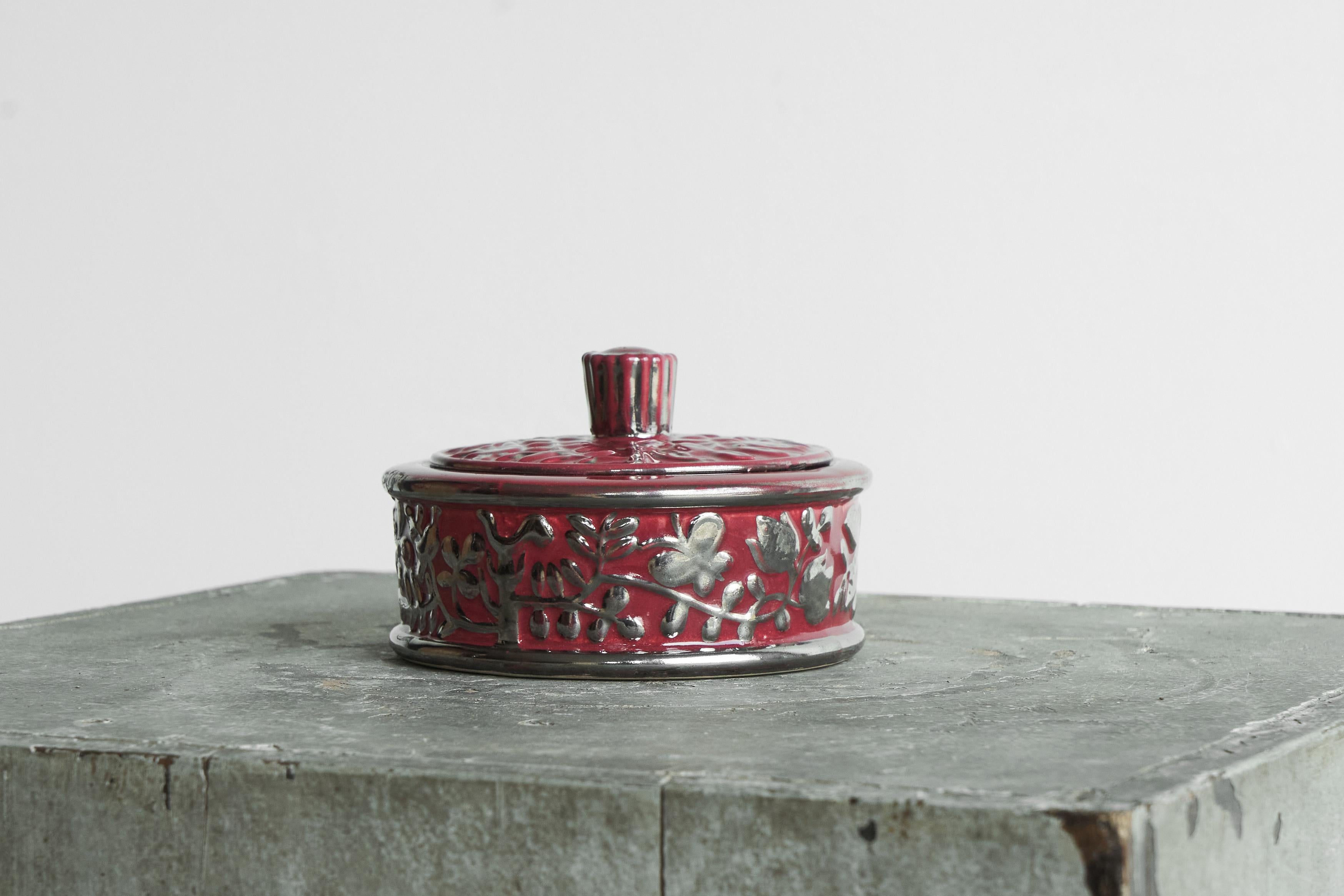 Ciotola con coperchio rosa di Boch Frères Keramis con fiori e farfalle in argento, Belgio, inizio XX secolo.

Si tratta di una splendida e decoratissima scatola con coperchio in ceramica con un bellissimo decoro di elementi floreali e farfalle in