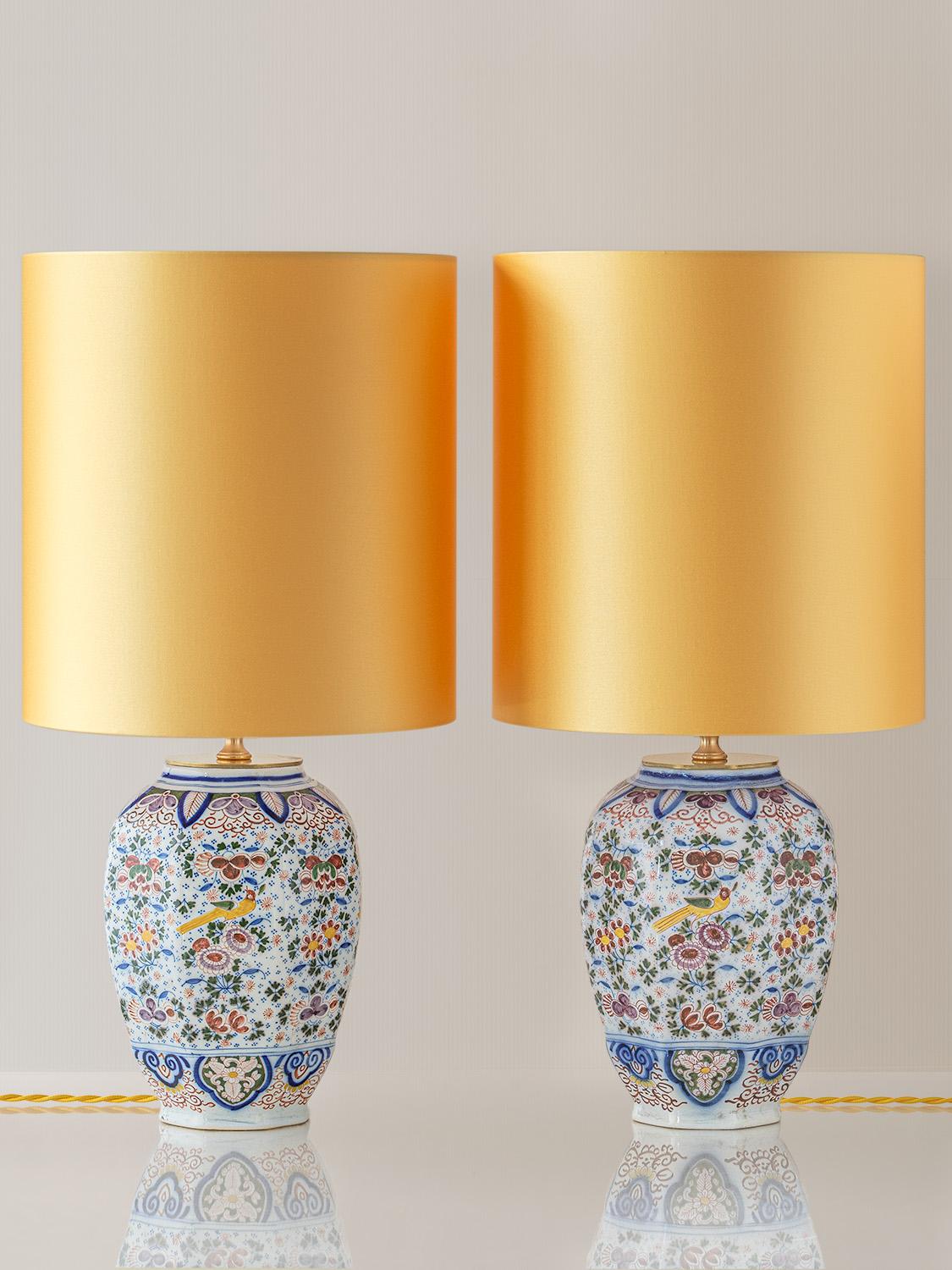 Meticulously handcrafted by Amitābha Studio in Amsterdam, this exquisite pair of table lamps is fashioned from rare antique Boch Frères Keramis vases (circa 1872-1900), designed in a captivating Delft Polychrome Chinoiserie style. Named “Goudvink”