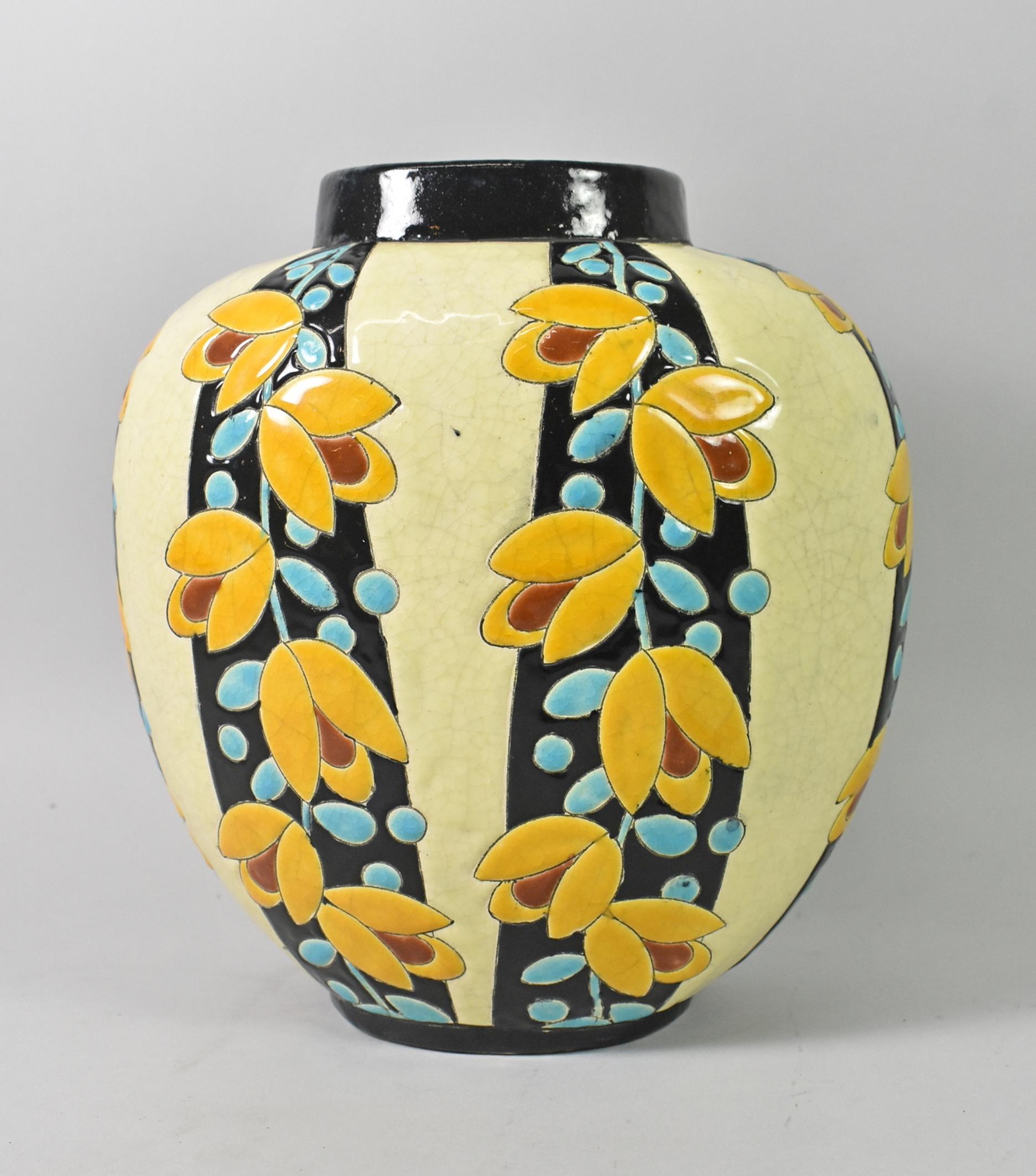 This beautiful Art Deco vase by Charles Catteau for Boch Freres is black and butter yellow and decorated with aqua stems and leaves with mustard and rust flowers. This piece has a crackled enamel finish and is 9 1/4