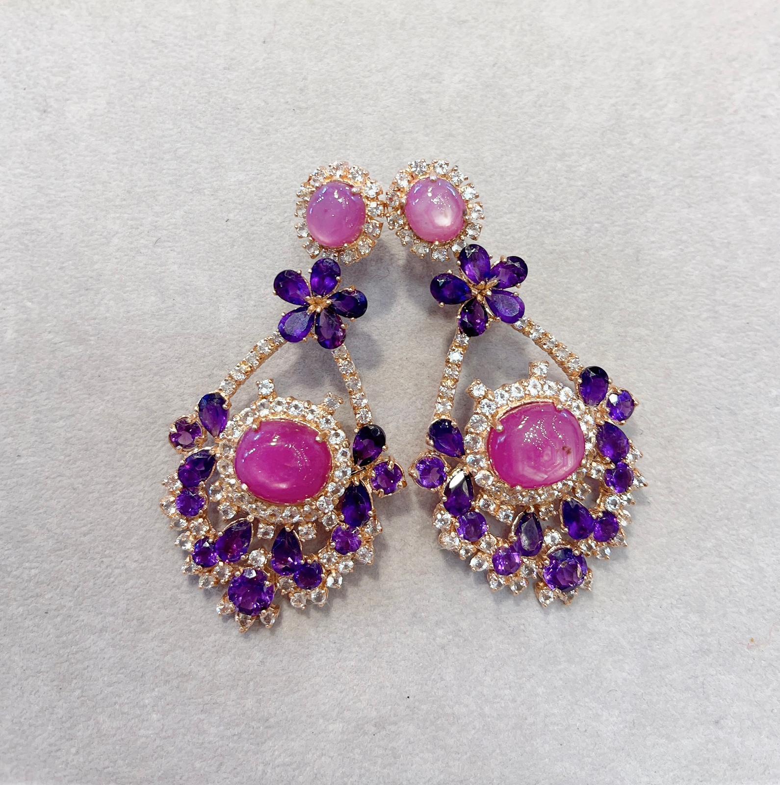 Bochic Earrings
Drop style 
Natural Pink Star Ruby Cabochons
18 Carats 
Shape - Cabochon
Natural Purple Amethysts
17 Carats 
Shape - Pear shapes 
White Natural Round Brilliant Topaz 
4 Carats 
Set 22k gold and Silver 
Vintage style “Capri” Earrings.
