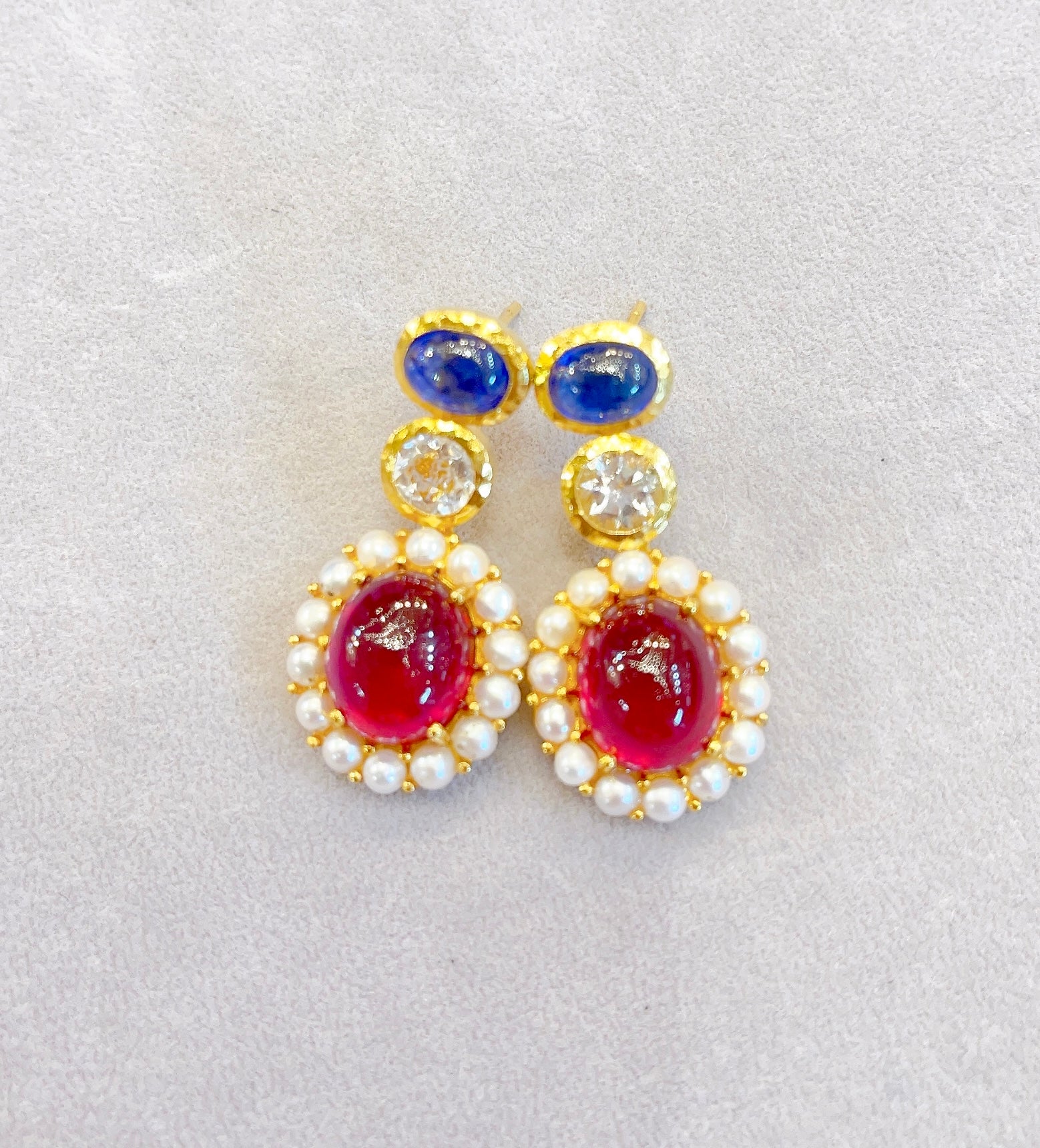 Bochic Drop Earrings
Ruby Natural / Cabochon / 19 Carat 
Sapphire Natural / Cabochon / 5 Carat 
White Topaz Natural / Round Brilliant / 2 Carat 
White pearls 
Silver and 22K Gold plating 
Gold Plating to 3 microns 
This earrings is perfect to wear