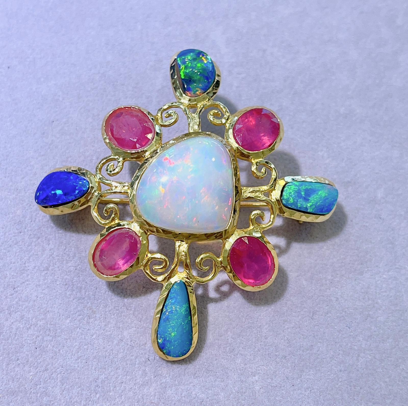 Bochic “Capri” Blue Fire Opal, White Ethiopian Opal & Ruby Brooch 
From the “Capri” collection 
Natural White Opal - 14 carats 
Natural Blue Opals - 11 carats 
Natural shapes 
Natural Ruby Cabochon - 16 carats 
Oval Brilliant shape 
Set in 22K Gold