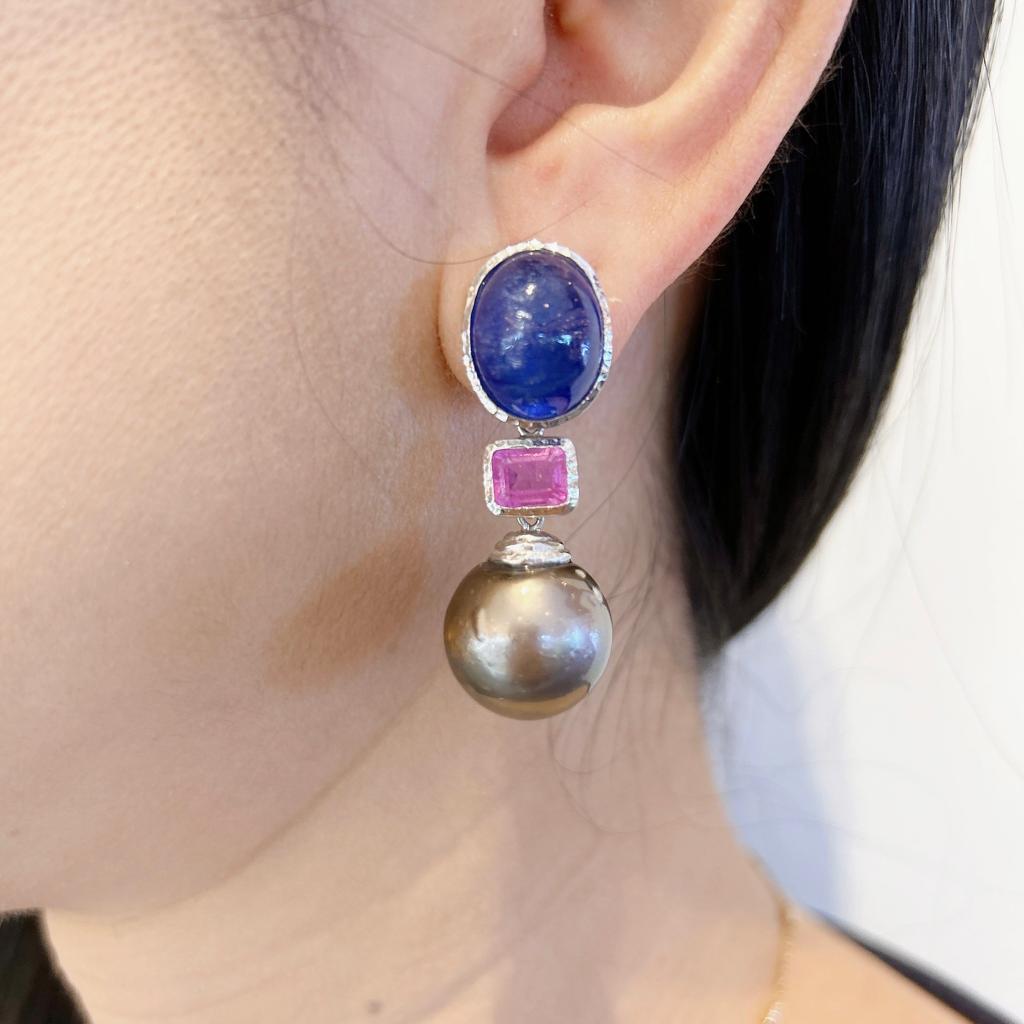 Bochic “Capri” Blue Sapphire & Tahiti Pearl Earrings Set In 18K Gold & Silver 
Blue sapphires - 26 carats 
Cabochon shapes 
Red/ Pink Rubies - 2 carats 
Emerald cuts 
From Sri Lanka 
South Sea Tahiti Pearls 
Gray color with pink tone
The earrings