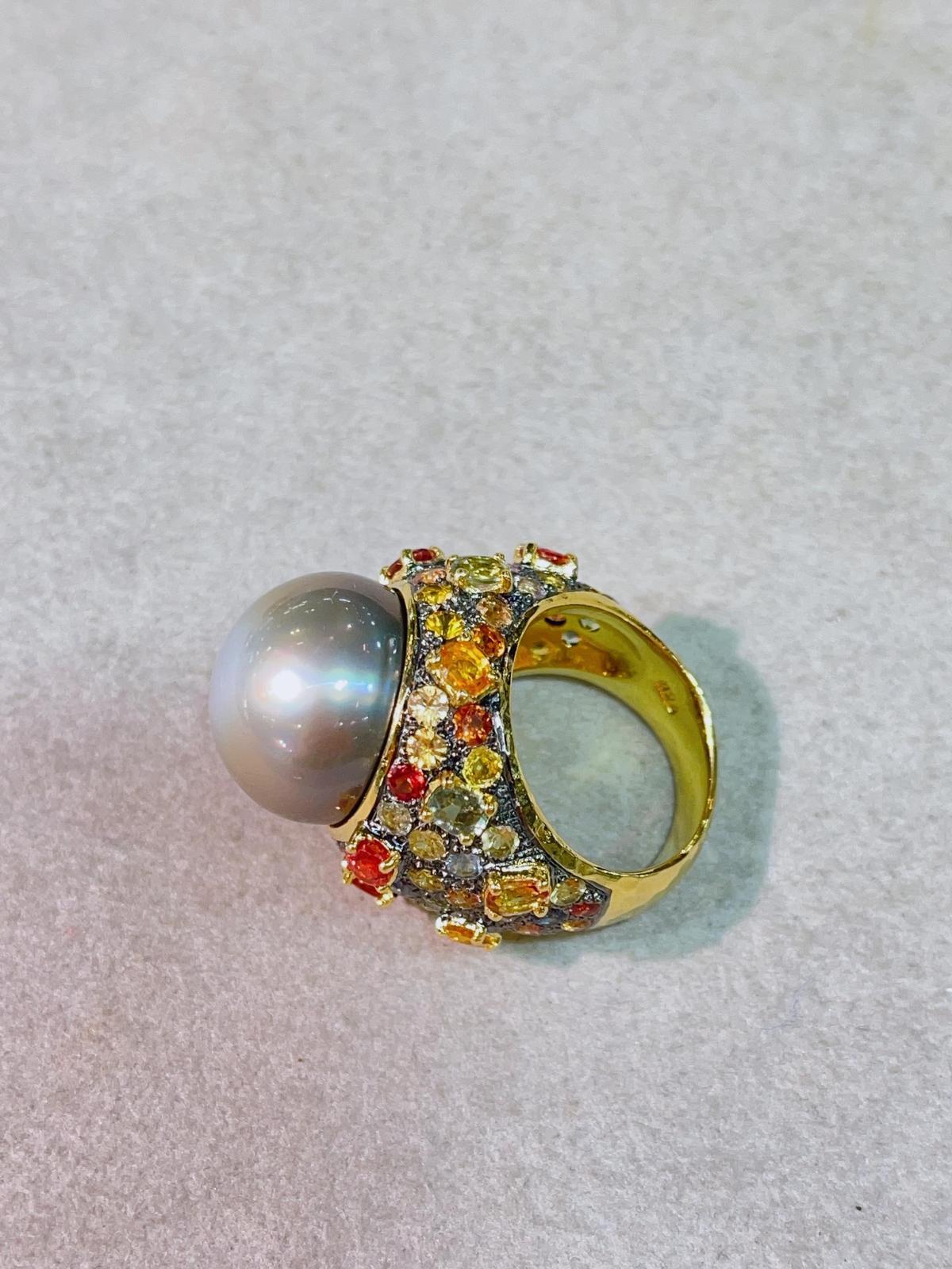 Bochic Capri Ring aus 18 Karat Gold und Silber mit mehreren Saphiren und Tahiti-Perlen 
Natürliche Saphire aus Sri Lanka - 7 Karat 
Runde Brilliante Formen 
Farben: Rosa, Gelb, Rot, Orange, Blau 
Südsee Tahiti-Perle grau mit rosa Farbton 
Dieser