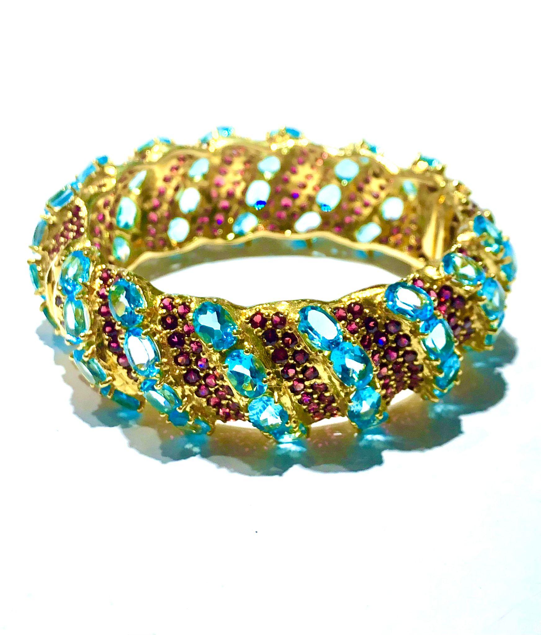 Bochic “Capri” Natural Ruby & Blue Topaz Bangle Set In 18K Gold & Silver

Natural Rubies - 4 Carat 
Natural Blue Topaz  - 14 Carat 

This Bangle is from the 