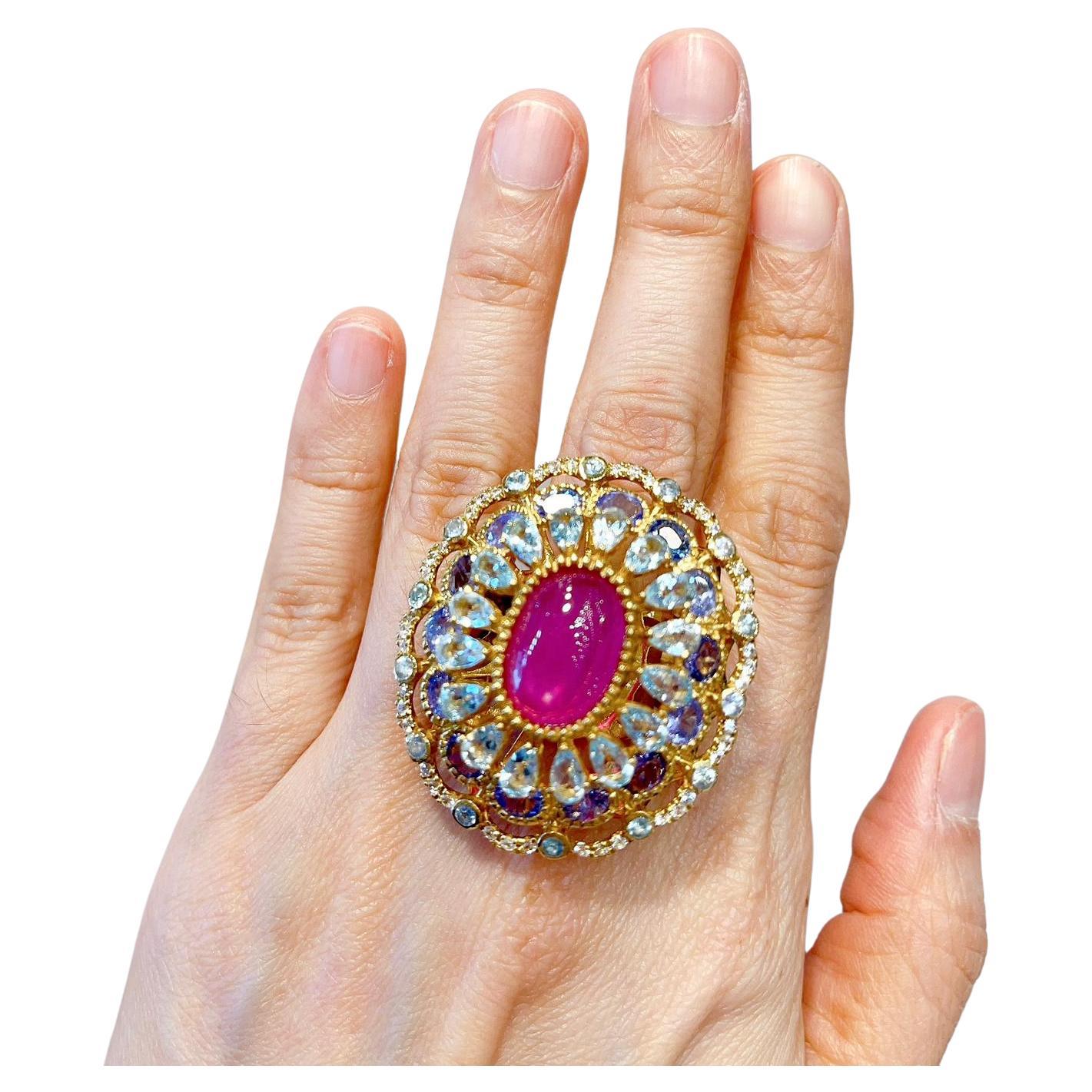 Bochic Cocktail-Ring mit rotem Rubin, Tansanit, blauem und weißem Topas 
Rubin Natural Cabochon in der Mitte 
Farbe - Rot / Rosa 
7 Karat 
Runde Brillanten Natürliche Tansanite 
Farbe - Lila / Violett 
10 Karat 
Birnenförmiger und runder