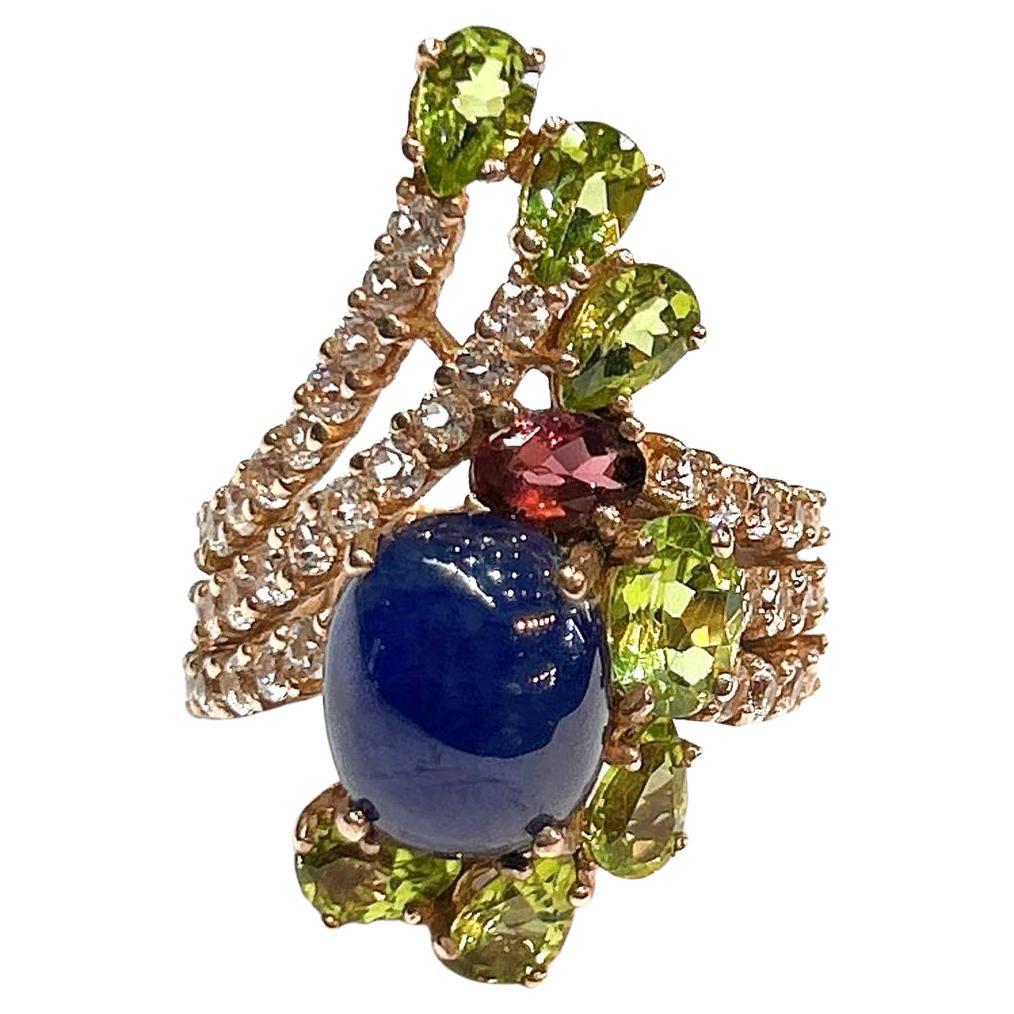 Bochic “Orient” Blue Sapphire & Multi Gem Cocktail Ring In 18K Gold & Silver 

Natural Blue Sapphire Cabochon - 3 Carat 
Natural Deep Rose Garnet  - 1.50 Carat 
Natural Green Amethyst - 5 Carat 
Natural White Topaz - 2 Carat 

This Ring is from the