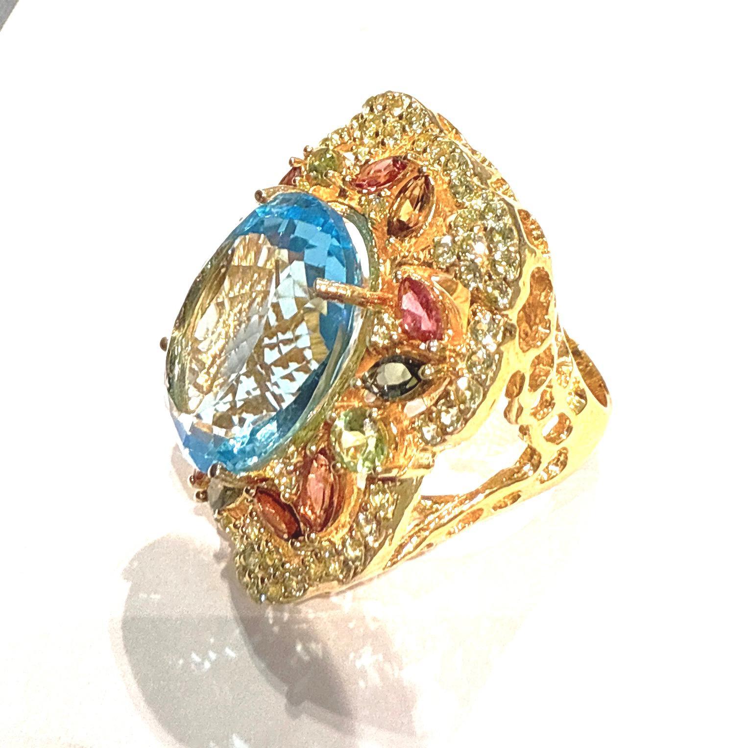 Bochic “Orient” Blue Topaz & Multi Gem Cocktail Ring Set In 18K Gold & Silver 

Natural Blue Topaz  - 12 Carat
Natural Rose Rodorite - 4  Carat 
Natural Green Tsavorite - 4 Carat 
Natural Green Amethyst - 3 Carat
Natural White Topaz - 2 Carat 

This