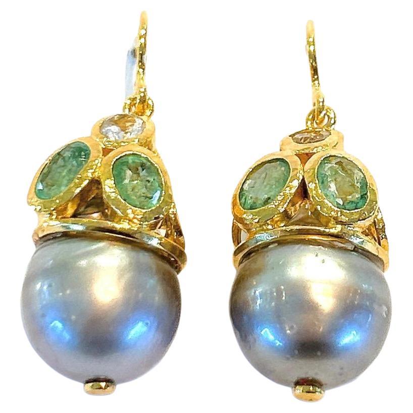 Bochic “Orient” Emerald & South Sea Pearl Earrings Set In 18K Gold & Silver 
Green Natural Emeralds, Oval Shape - 3 Carats 
South Sea Natural Tahiti Pearl Drops, Gray/Silver Color with Pink Tone  
The earrings from the 