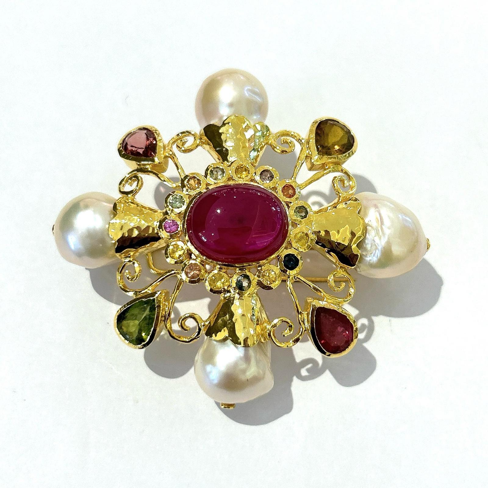Bochic “Orient” Multi Sapphires & Ruby Brooch Set In 18K Gold & Silver 

Natural Red Ruby, Oval shape - 15 carat 
Multi color Natural Sapphires from Sri Lanka 
2 carat
Natural Tourmaline - 5 Carats 
White South Sea Pearls 

The Brooch is from the