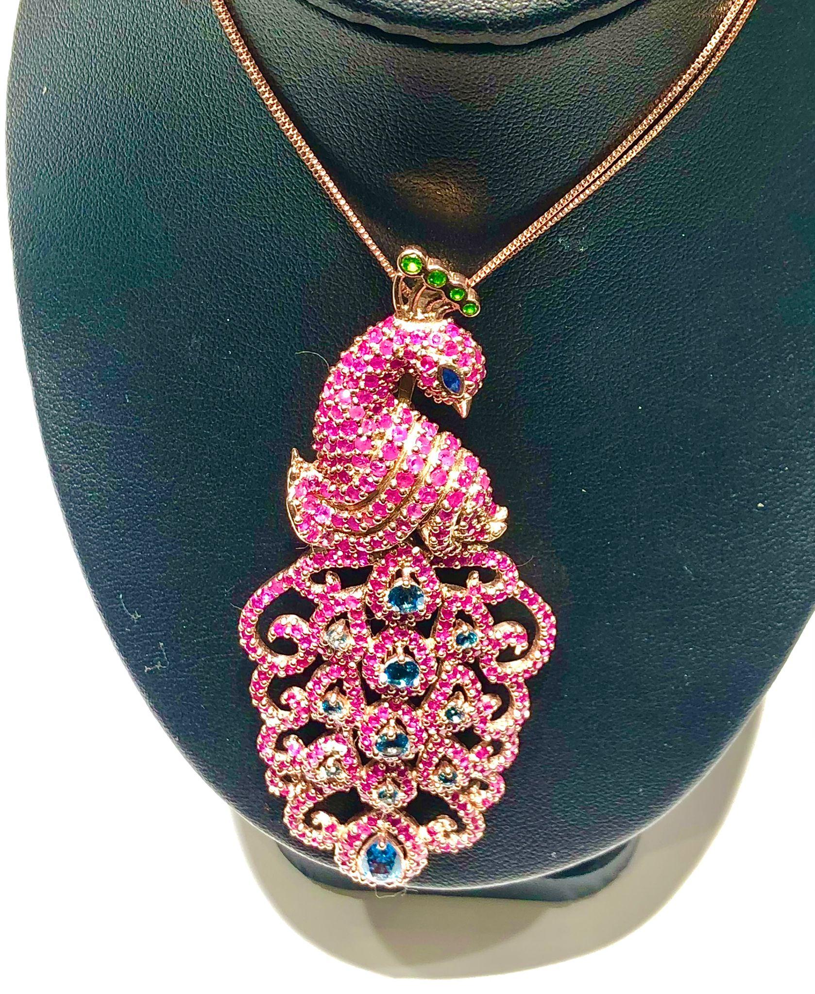 Bochic “Orient” Natural Ruby, Emerald & Sapphire  Peacock Brooch/Pendant Set 18K Gold & Silver 

Can be worn as Brooch or Pendant 

Natural Rubies 
7 carat  
Natural Emeralds, Sapphires & London Blue Topaz 
3 carat

The Brooch is from the 