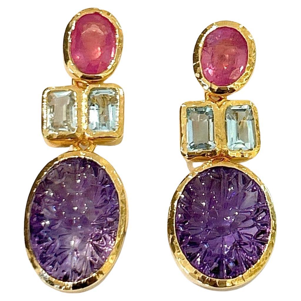 Bochic “Orient” Ruby & Topaz & Carved Amethyst Earrings Set In 18K & Silver 

Natural Blue Topaz  - 2 carats - Pear Shapes 
Natural Ruby -2 carats - Oval shape 
Natural Carved Amethyst - 6 carats - oval carved shapes 

The earrings from the 