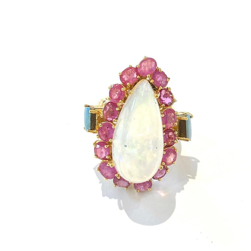 Bochic “Orient” White, Blue Opal, Red Rubies Cocktail Ring, 18K Gold & Silver

Natural Red Ruby Oval Shape - 5 Carats 
Natural Pear Shape Cut white Color Ethiopian Opal - 16 Carats 
Blue Square cut Australian opals set on the side of the ring 

This