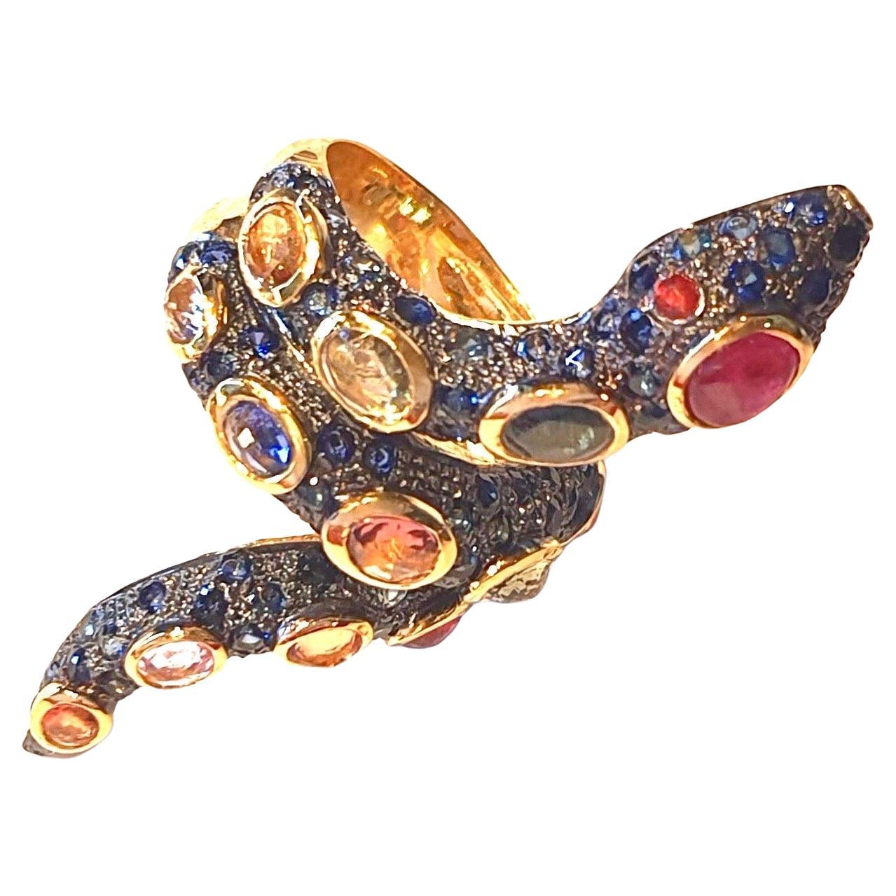 Bochic Serpent Fancy Sapphire & Ruby Ring 
Ruby Cabochon (Real)
Pink Natural Sapphire 
Green Natural Sapphire
Rose Natural Sapphire 
Light Blue Natural Sapphire
Red Natural Sapphire
Black Silver and 22 K Gold plating 
3 microns 
Comes with a Bochic