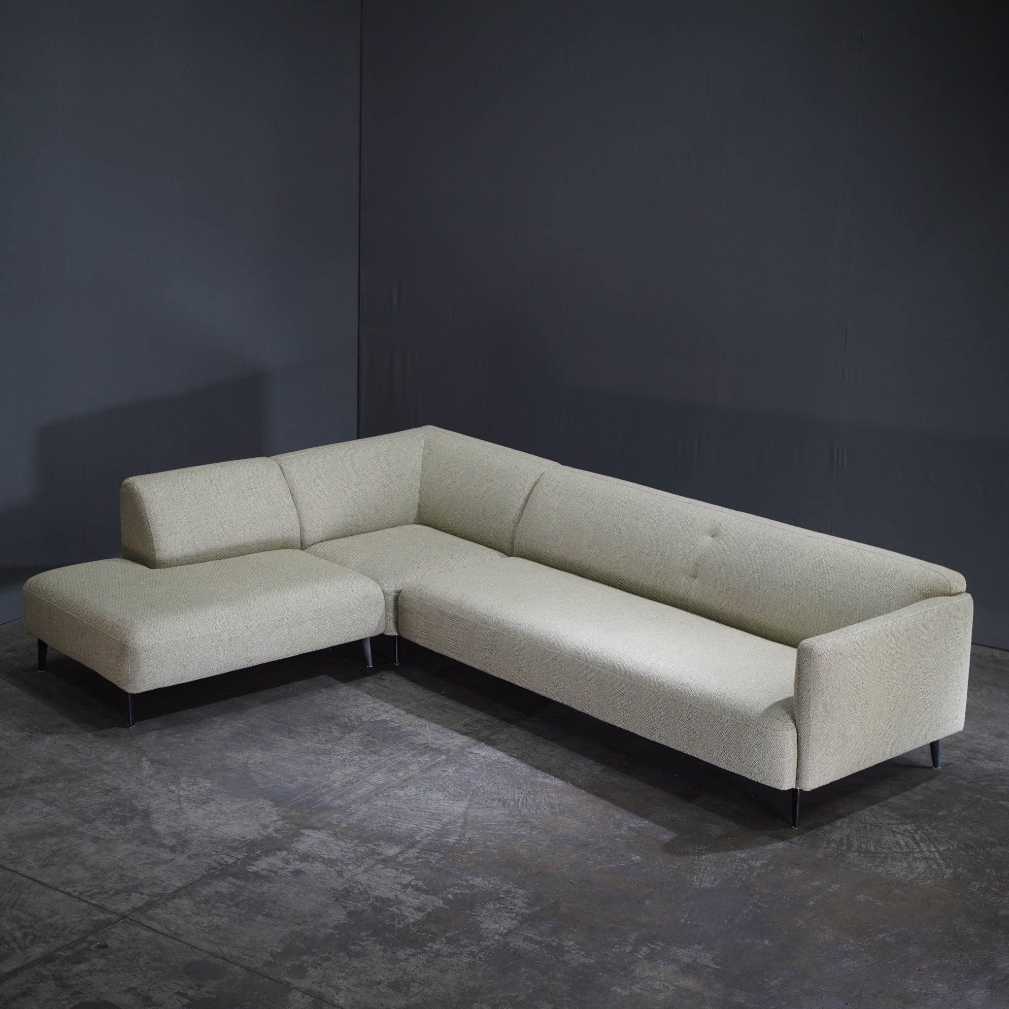 The BoConcept Modena Corner Sofa by Morten Georgsen epitomizes contemporary elegance and comfort. Upholstered in a luxurious cream fabric, this modular sofa features a sleek, low-profile design that enhances any living space with its understated