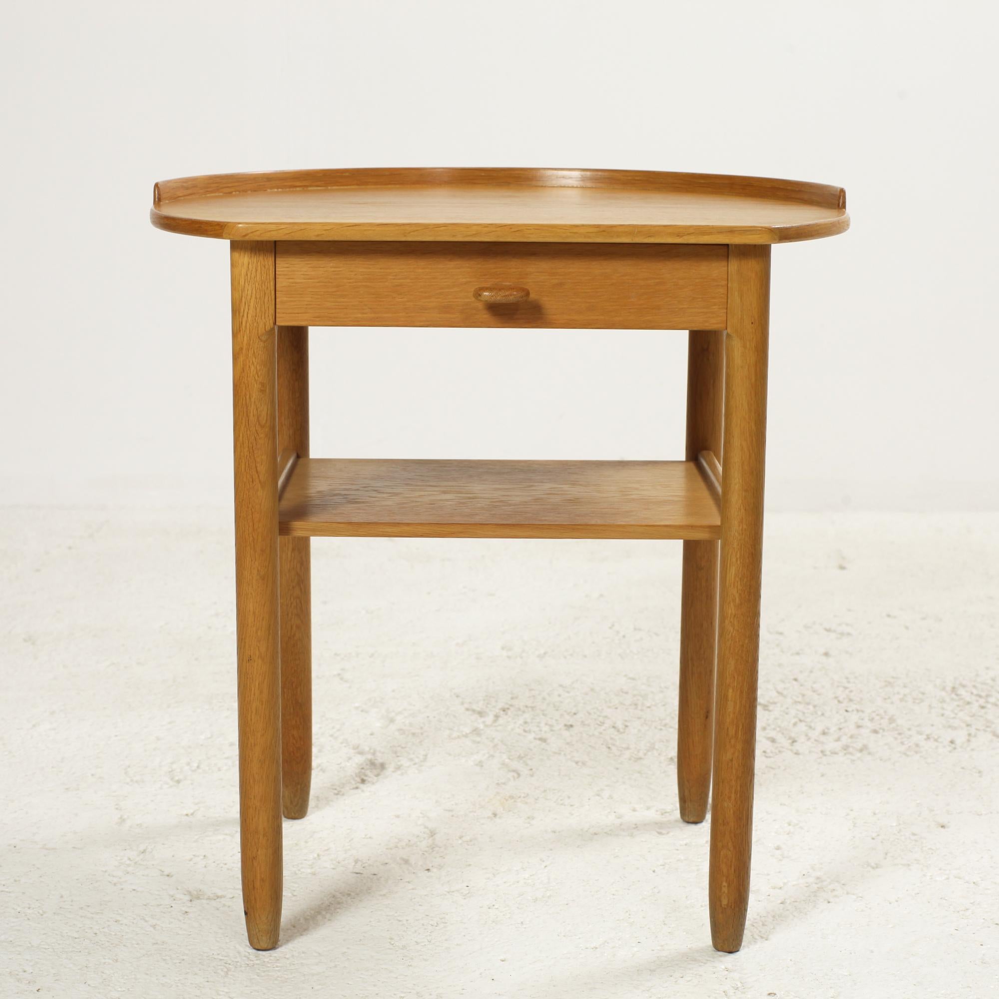 Oak bedside table or side table designed in the sixties by Sven Engström and Gunnar Myrstrand for Bodafors Sweden.
Elegant rounded design with nice details like sculpted drawer handles and a rim around half the table tops.
Stamped.