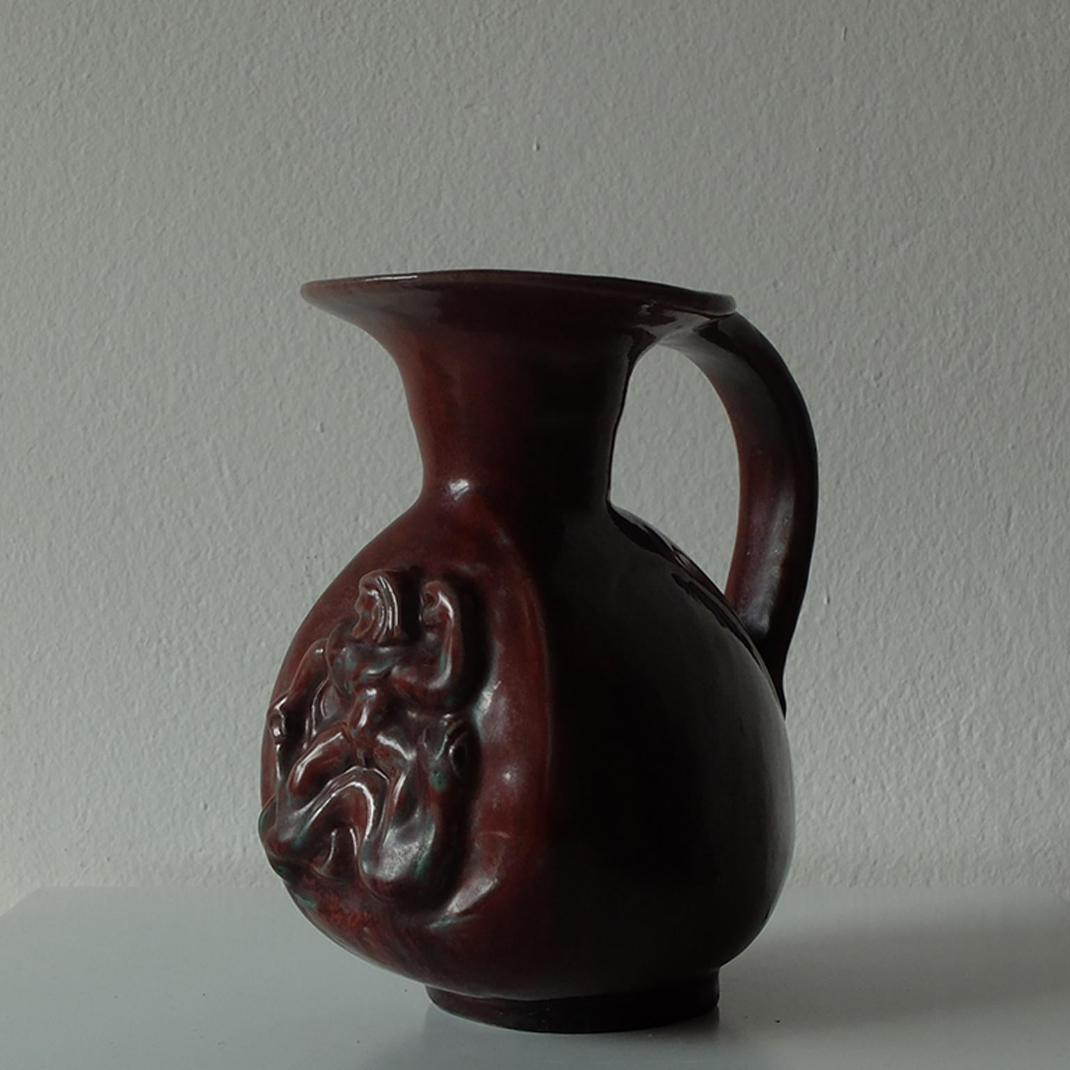 Bode Willumsen for Royal Copenhagen, beautiful footed stoneware pitcher in rare deep earthy red glazed ceramic, 1940s.

Designed by Danish ceramist Bode Willumsen and manufactured by Royal Copenhagen in the early 1940s, this piece is fully signed