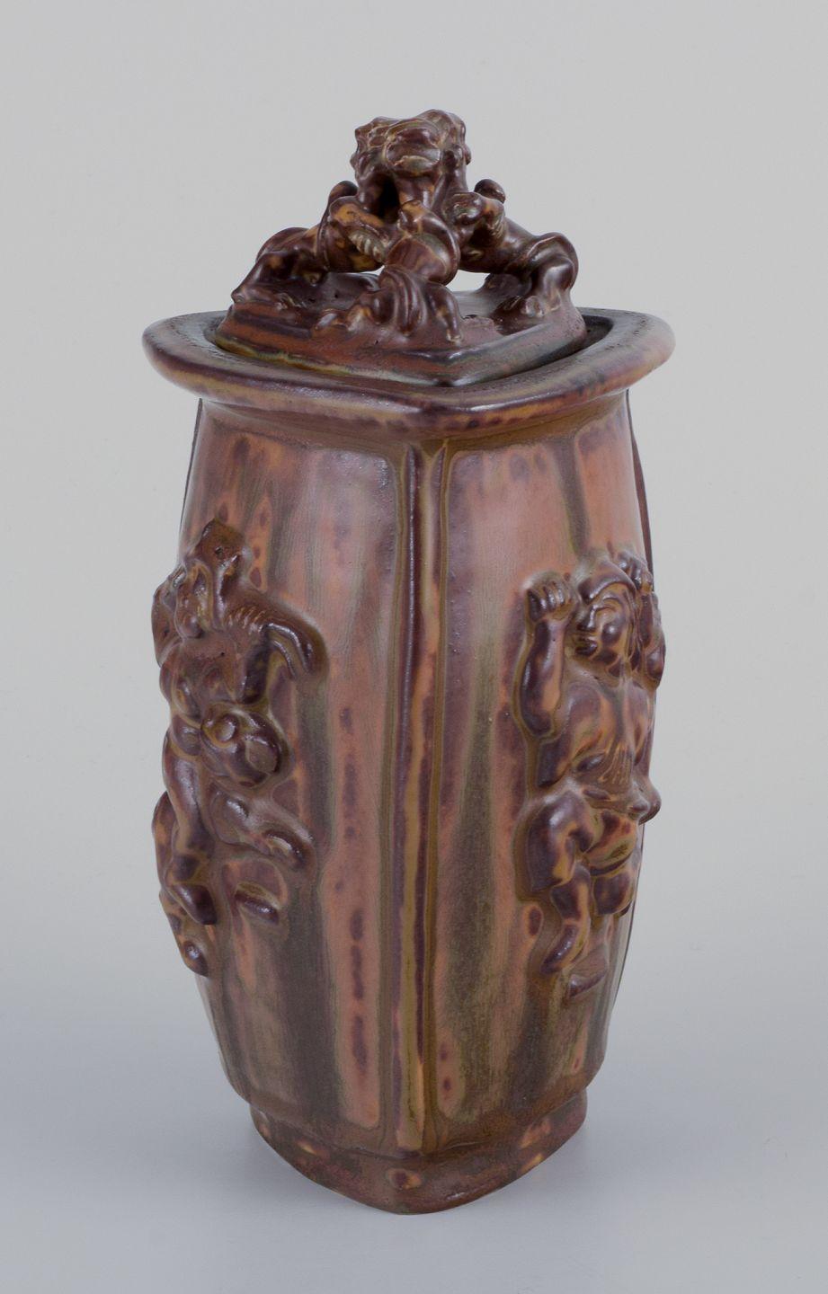 Pre-owned goods are exempt from import duties for U.S. customers. 
Therefore, no import tariffs will be applicable to your purchase.

Bode Willumsen (1895–1987) for Royal Copenhagen.
Lidded jar made of sung glazed earthenware, modelled with mythical