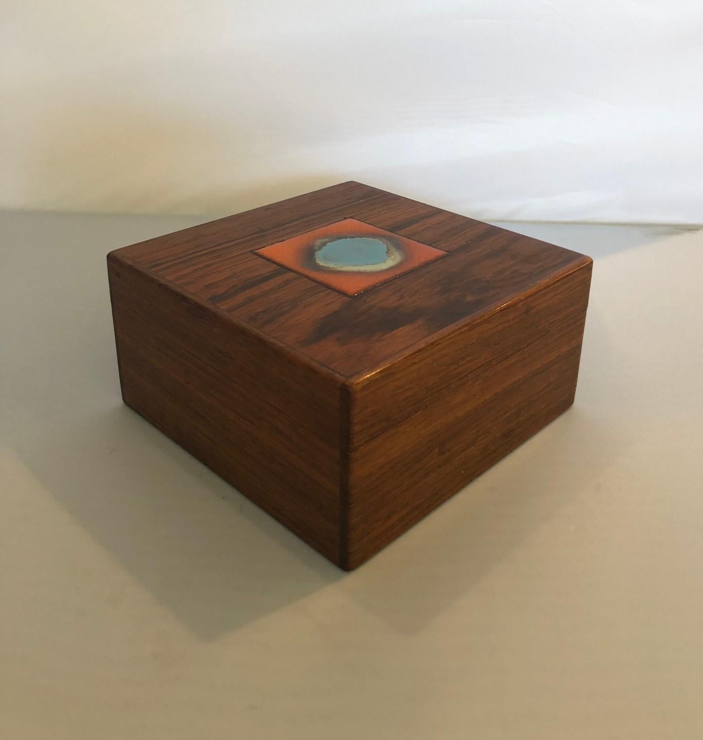 Beautifully crafted solid rosewood trinket box by Danish craftsman Alfred Klitgaard, circa 1960s. Very detailed construction and exquisite finish with a gorgeous Bodil Eje orange / light blue ceramic tile inset in the lid.

Measurements: 4.75
