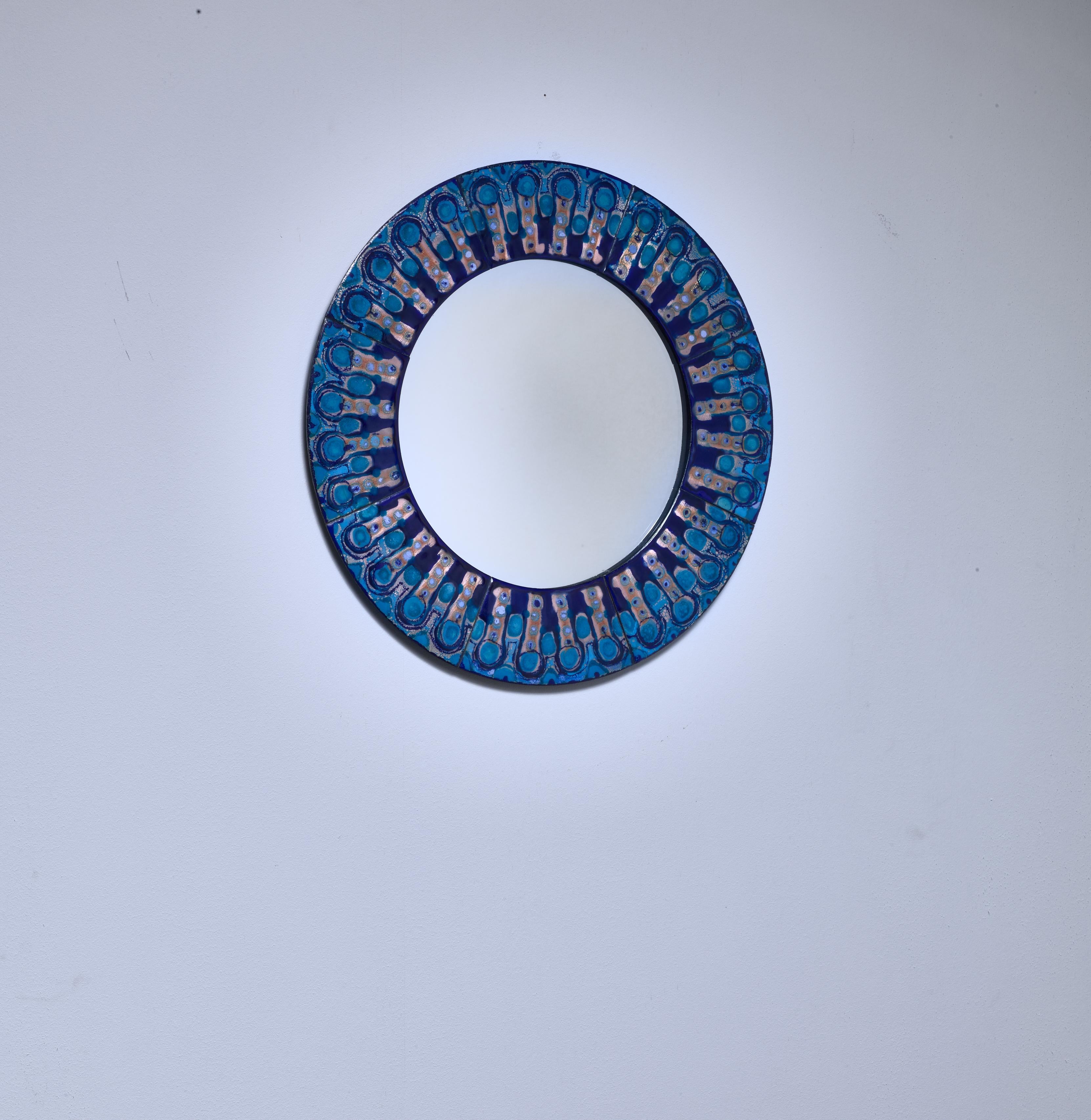 A round wall mirror by Danish designer Bodil Eje (1931-2006). The mirror has a frame made of polychrome enameled copper plates.

We also have a rectangular as well as large round Bodil Eje mirror in blue enamel available.