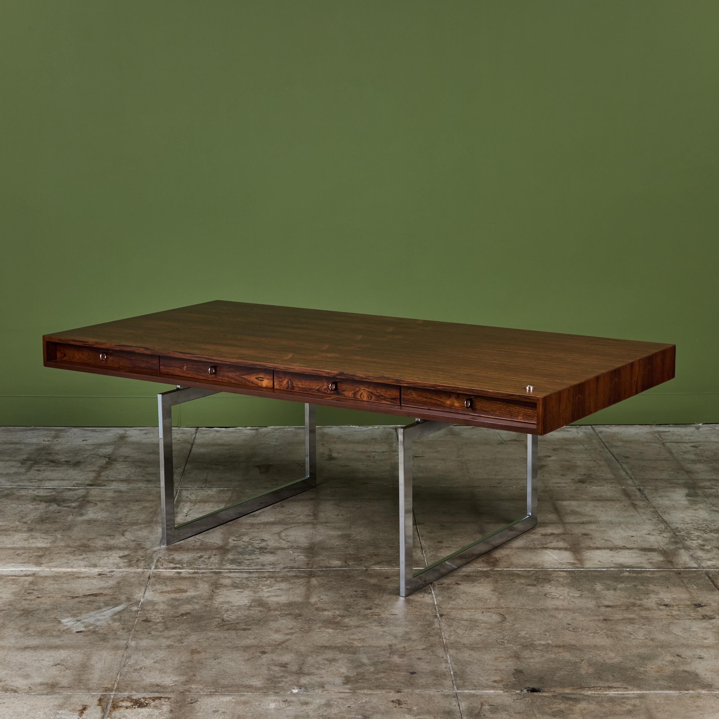 A stunning rosewood desk designed by Bodil Kjaer for E. Pedersen & Son Denmark, c.1950s, Denmark. Dubbed the James Bond desk for its many appearances in the franchises films, the desk features four drawers with round chrome pulls. The top of the