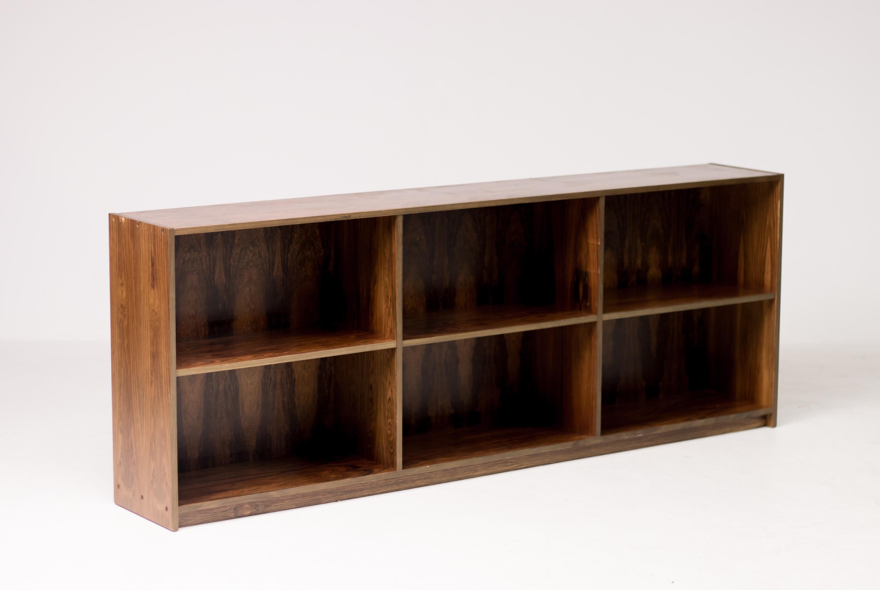 A sleek elegant and very modern Danish 1960s Brazilian rosewood bookshelf by E. Pedersen, Denmark, most likely designed by the queen of Danish modern, Bodil Kjaer. Bookmatched richly patinated rosewood, some scratches the top front edge.
Marked