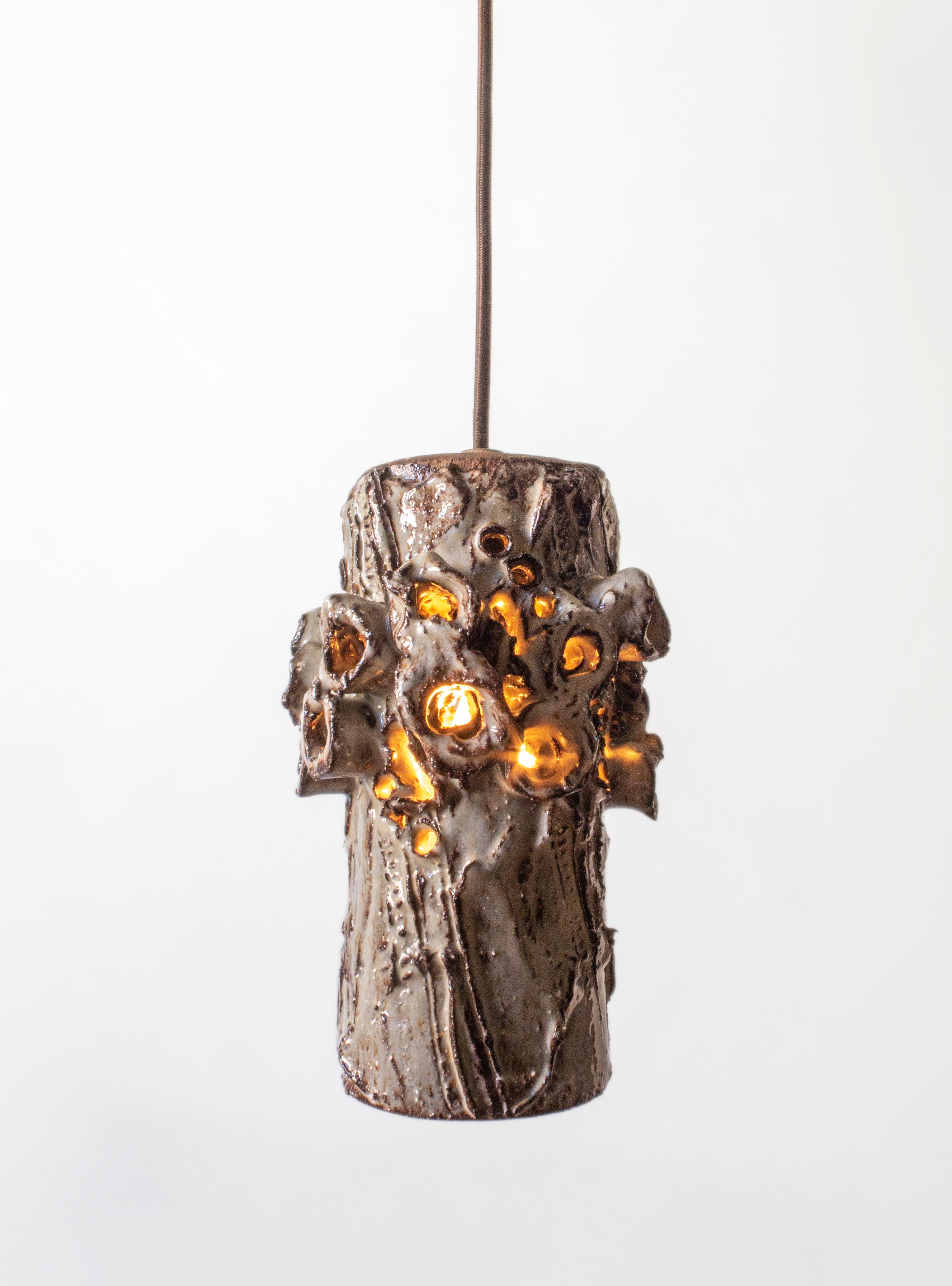 Each cylindrical body adorned in bold, projecting perforations and intricately sculpted ridges. The top stamped: Bodil Marie Nielsen Denmark. 

Height is easily adjustable. Each pendant holds one Edison standard base lightbulb. Canopy not