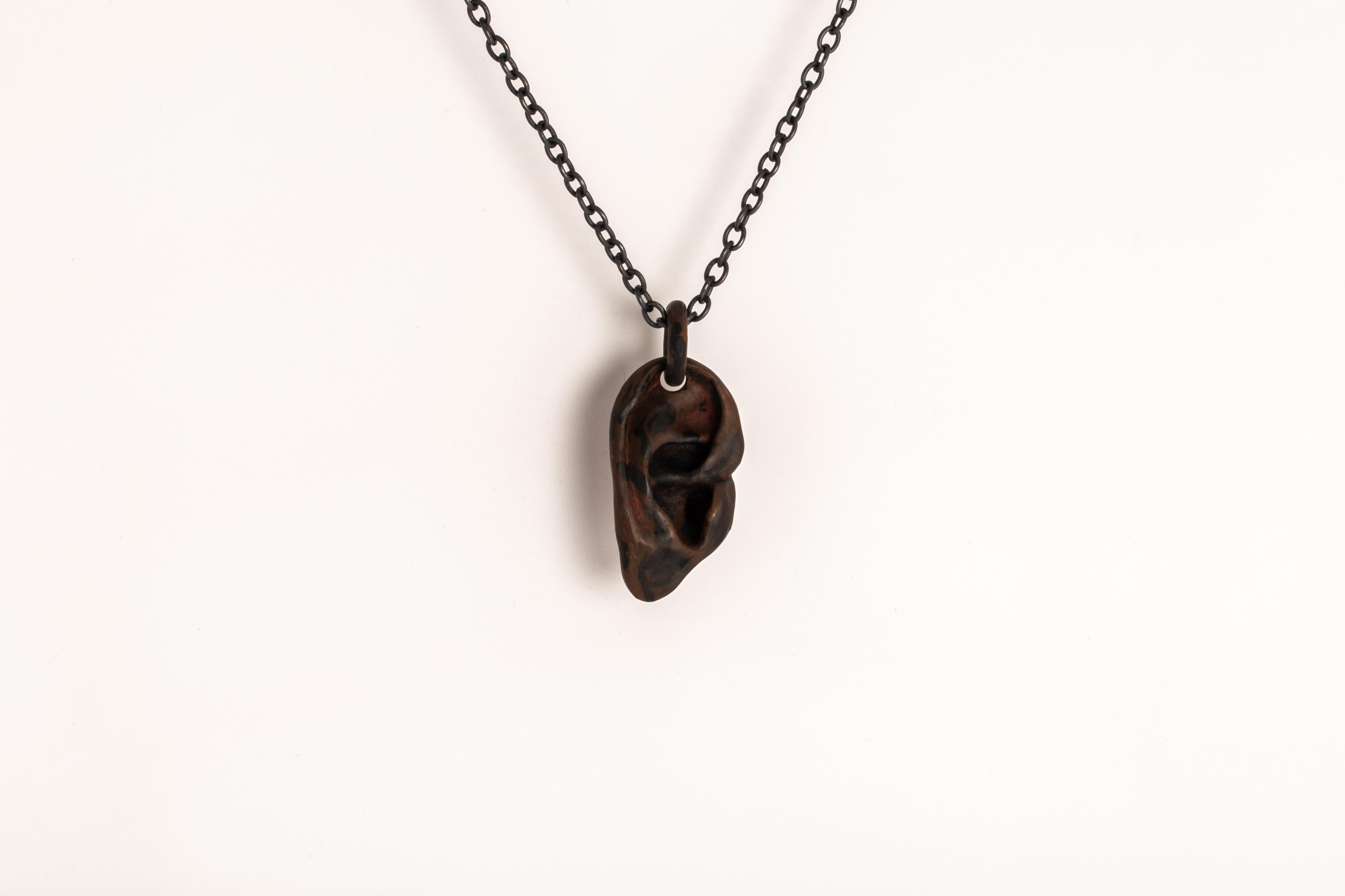 Pendant necklace in the shape of body part in burned brass, it comes on a 74cm sterling silver chain. This finish may fade over time, which can be considered an enhancement. Please note that Black Sterling tends to appear darker in photograph than