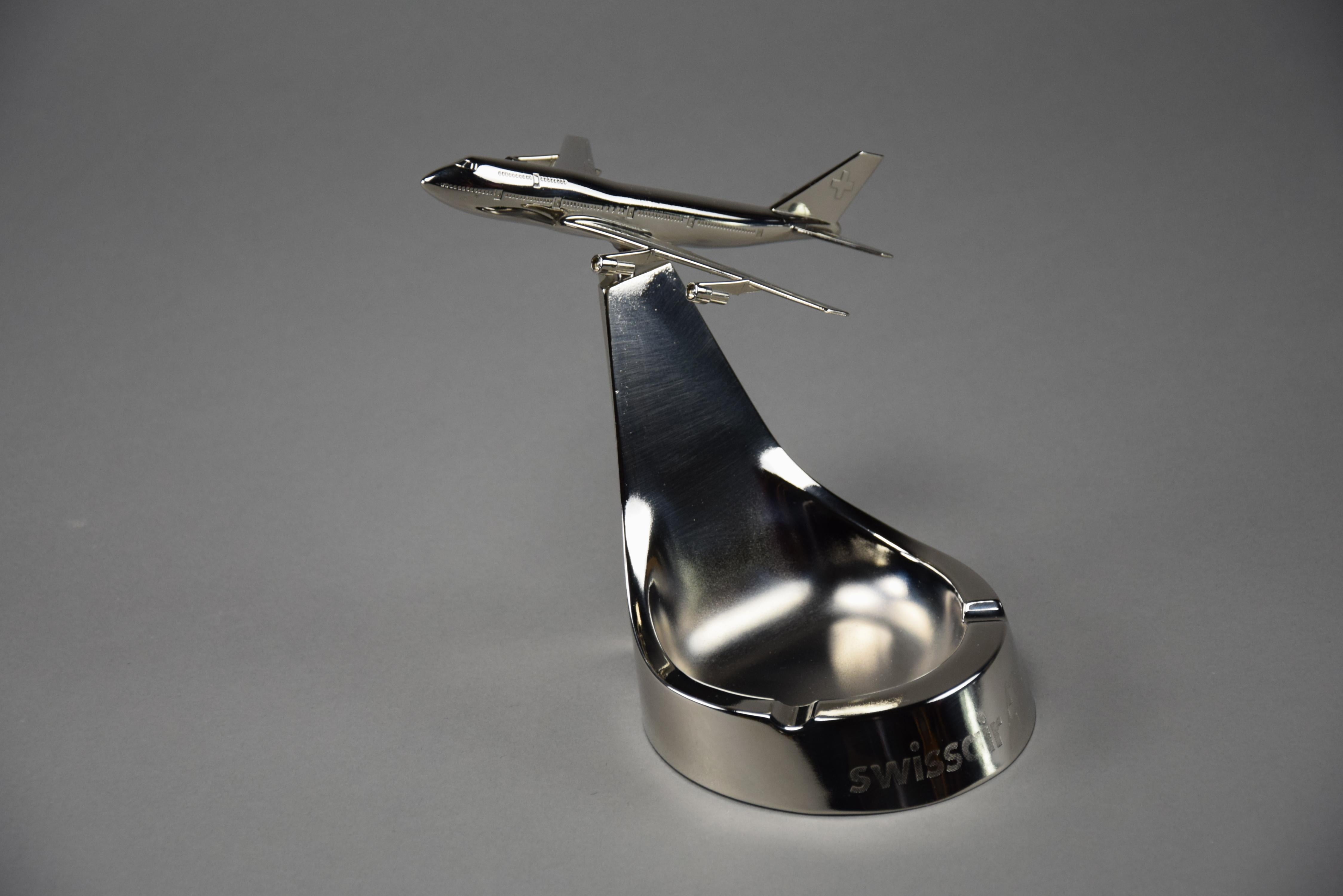 Extraordinary 1980s Chrome-Plated Boeing 747-300 Promotional Ashtray—a captivating masterpiece crafted by the renowned Swiss manufacturer, Buhler. This remarkable piece is not just an ashtray; it is a symbol of the majestic era of aviation and an