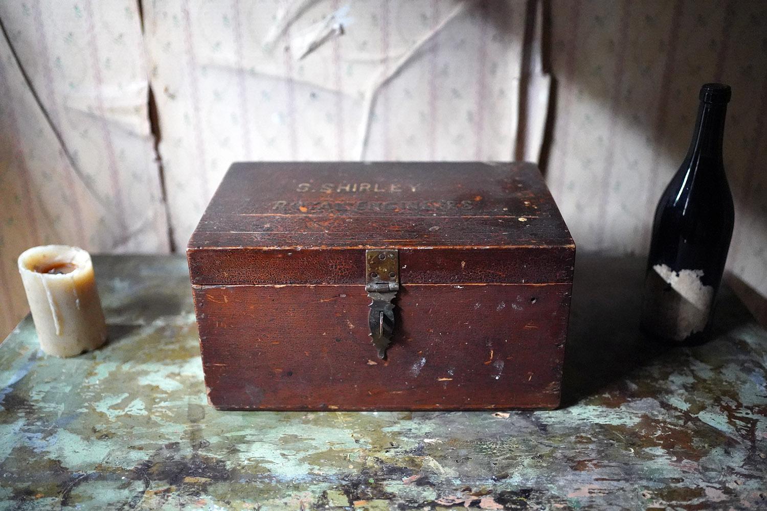 The painted pine traveling officer’s box, sign written to the top ‘S. Shirley Royal Engineers’, and richly textured in bitumen, opening to reveal a compartmentalised interior with upper slatted book shelf, bearing many officers’ tools and trinkets